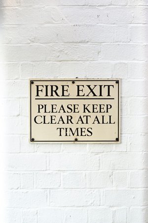 Fire exit sign on white brick wall
