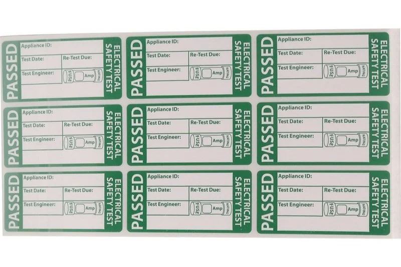 Multiple green and white electrical safety test tags marked 'PASSED' arranged in a grid pattern.