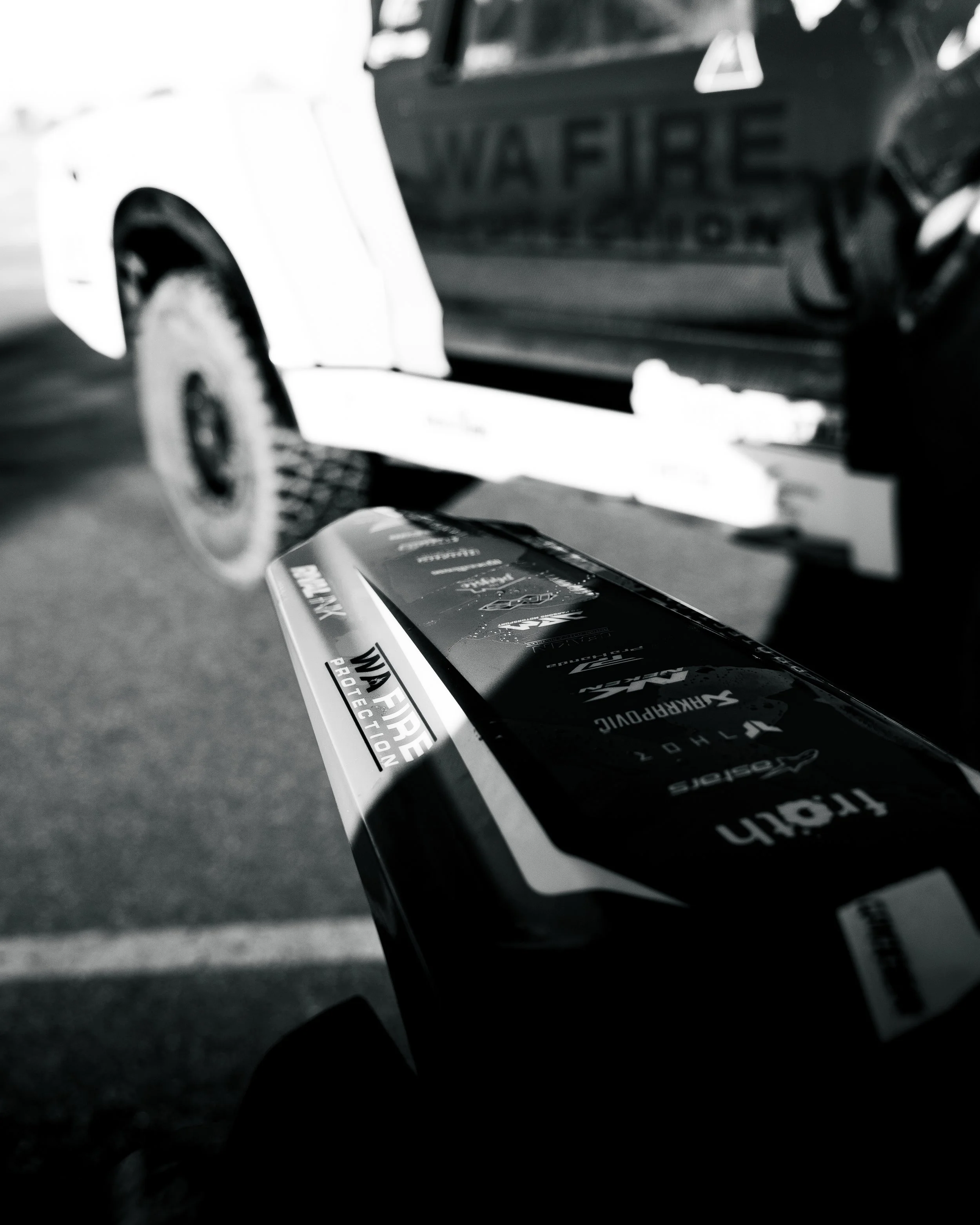 Close-up of a fire protection equipment package held in front of a vehicle with a partially visible sign that reads 'WAFIRE' and other text.