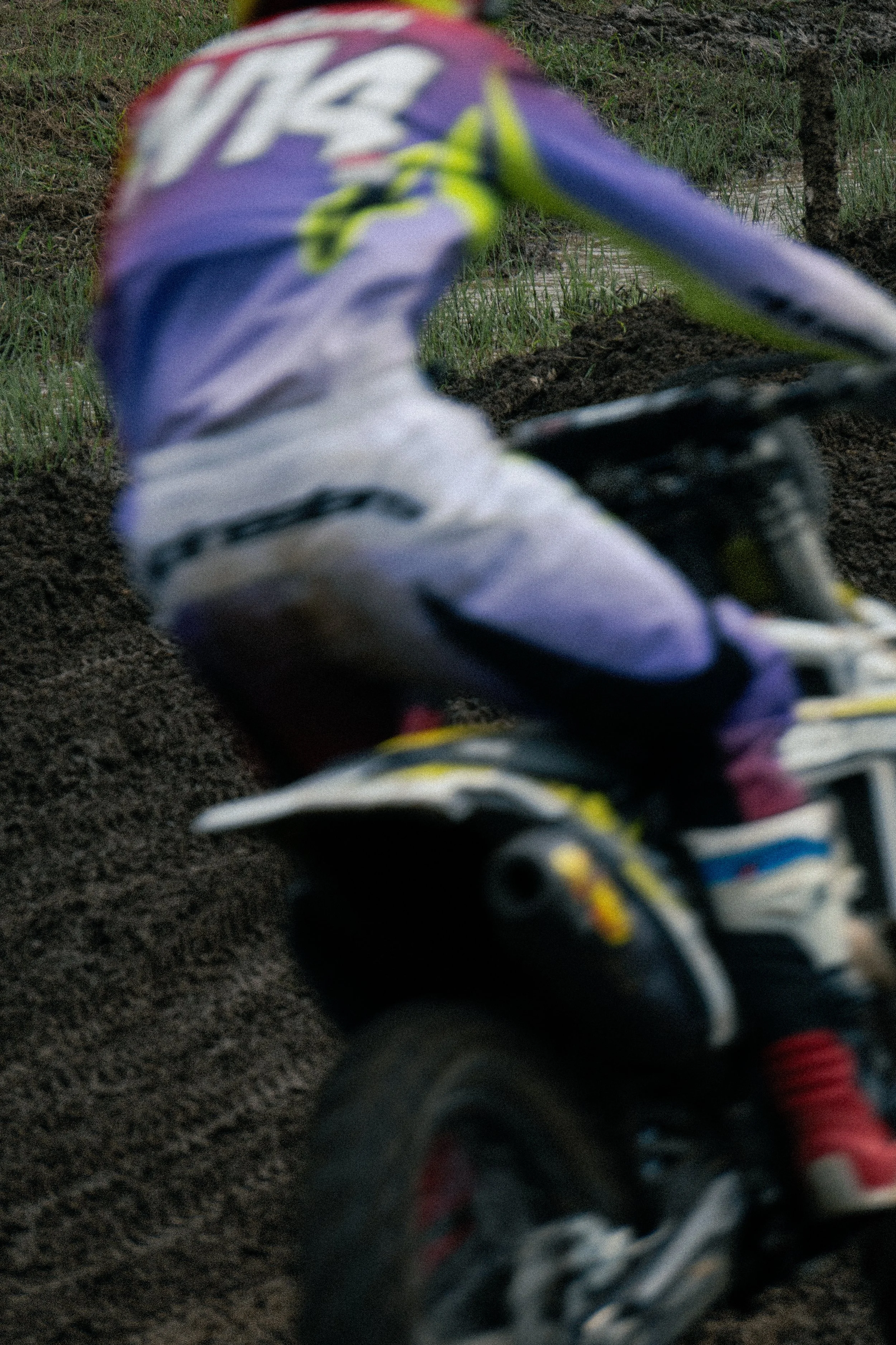 Close-up of a mountain biker's colorful shoe and part of their bike on dirt trail.