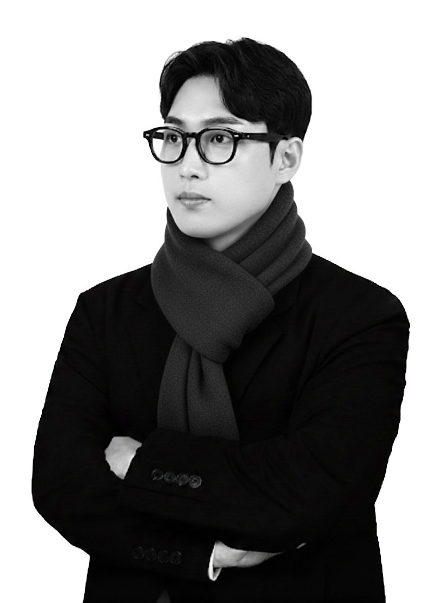 A black and white portrait of a young man wearing glasses, a dark blazer, and a thick scarf, with arms crossed and looking to the side.