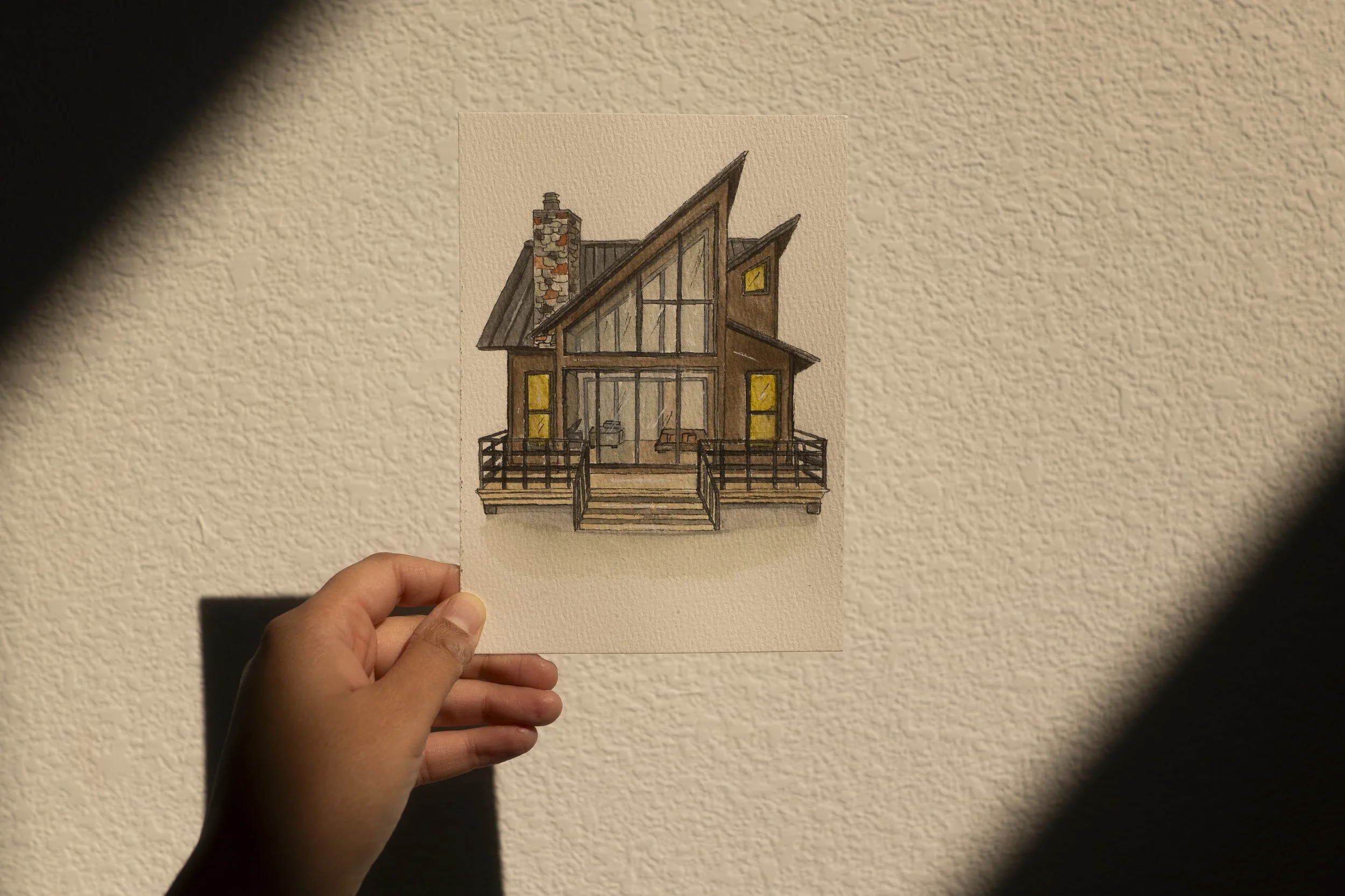 a photo of a brown cabin begin held up in front direct sunligh