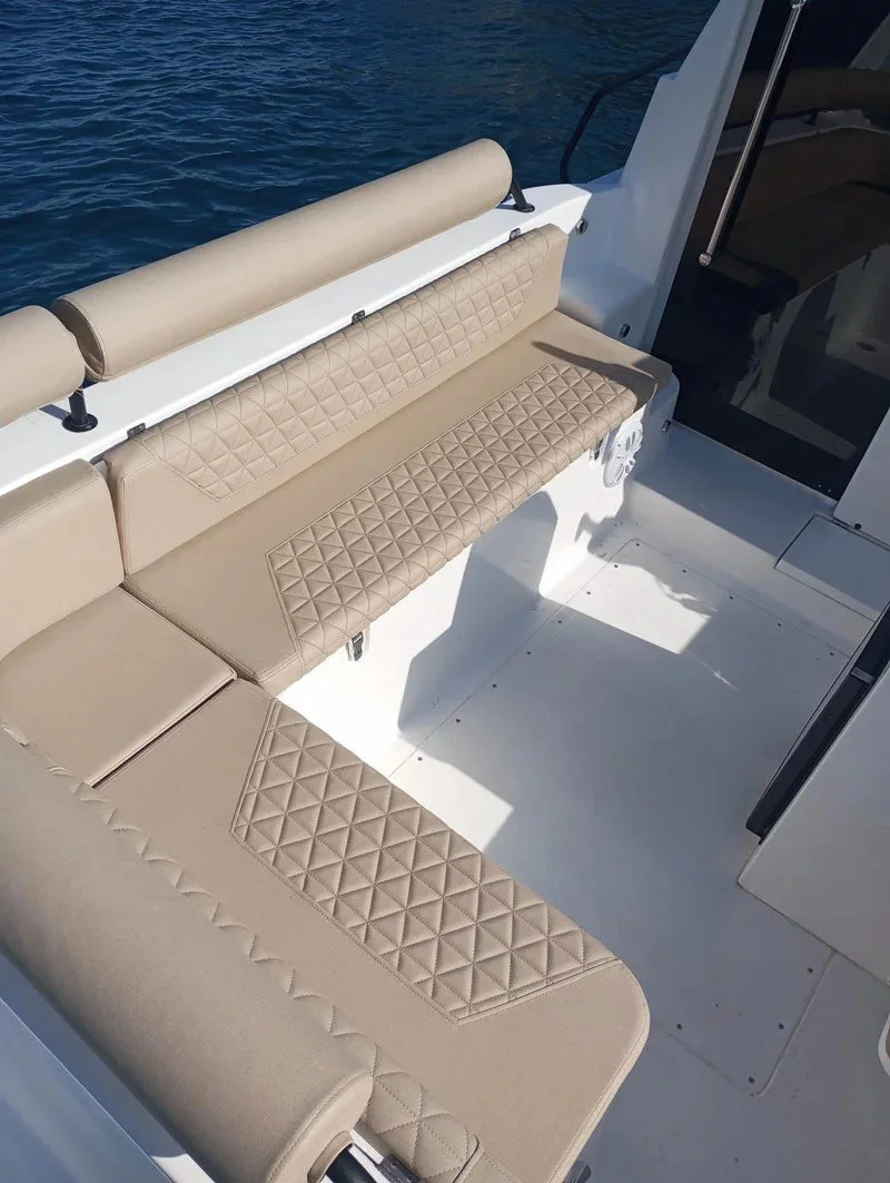 Beige cushioned seats on a boat with a water view.