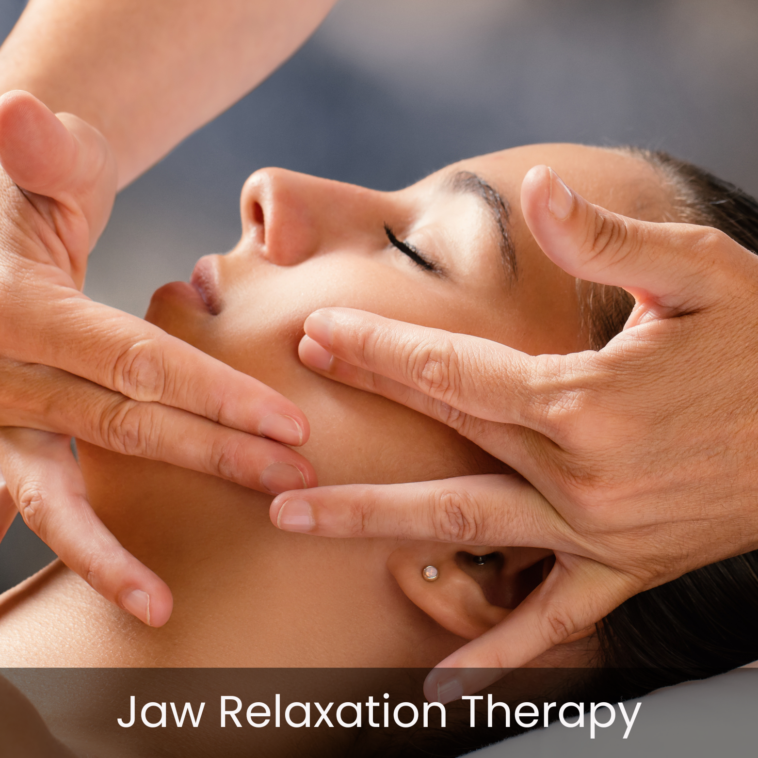 Close-up of a woman receiving jaw relaxation therapy, with a therapist gently holding her face and chin.