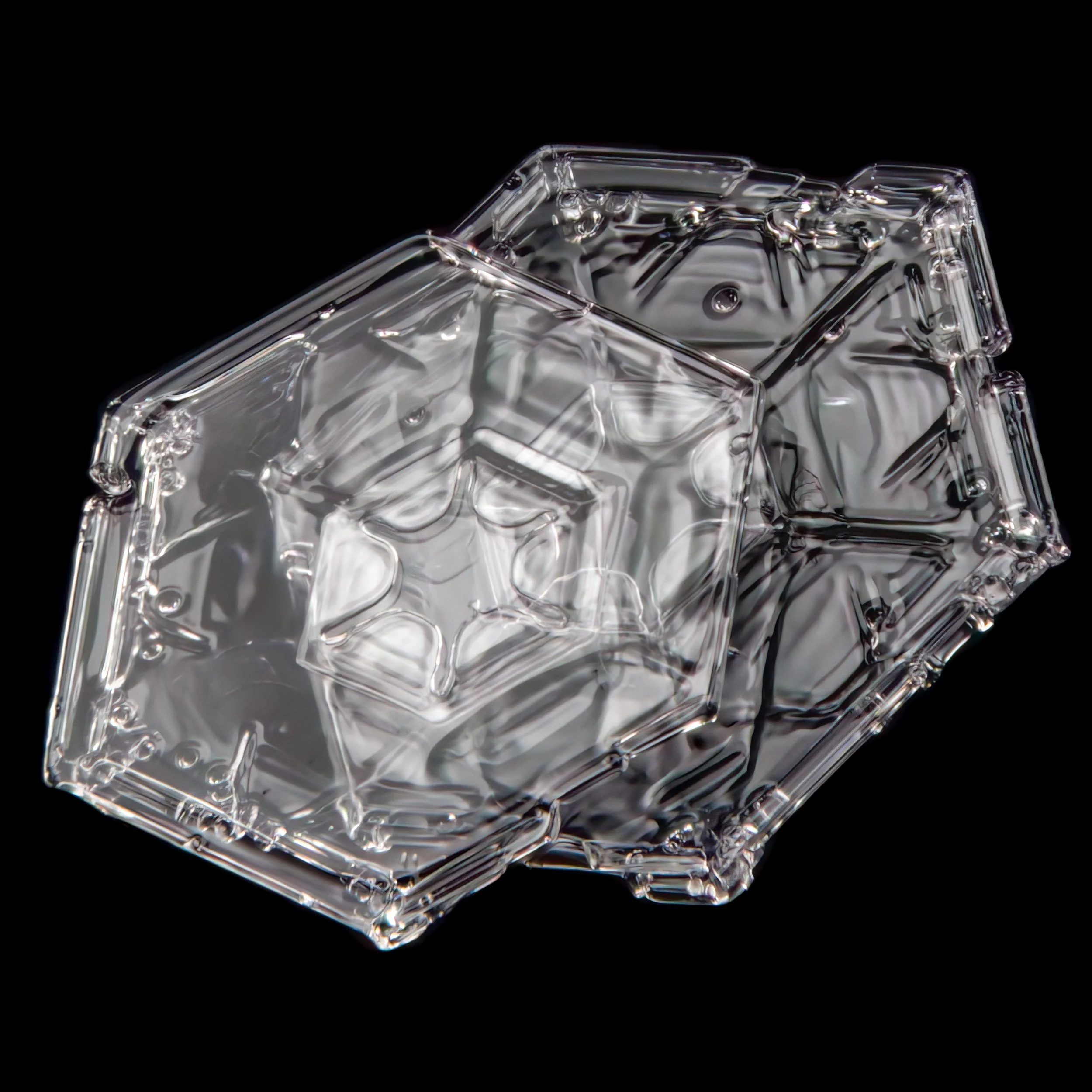 A macro photograph of two glassy plate-shaped snow crystals attached to each other.