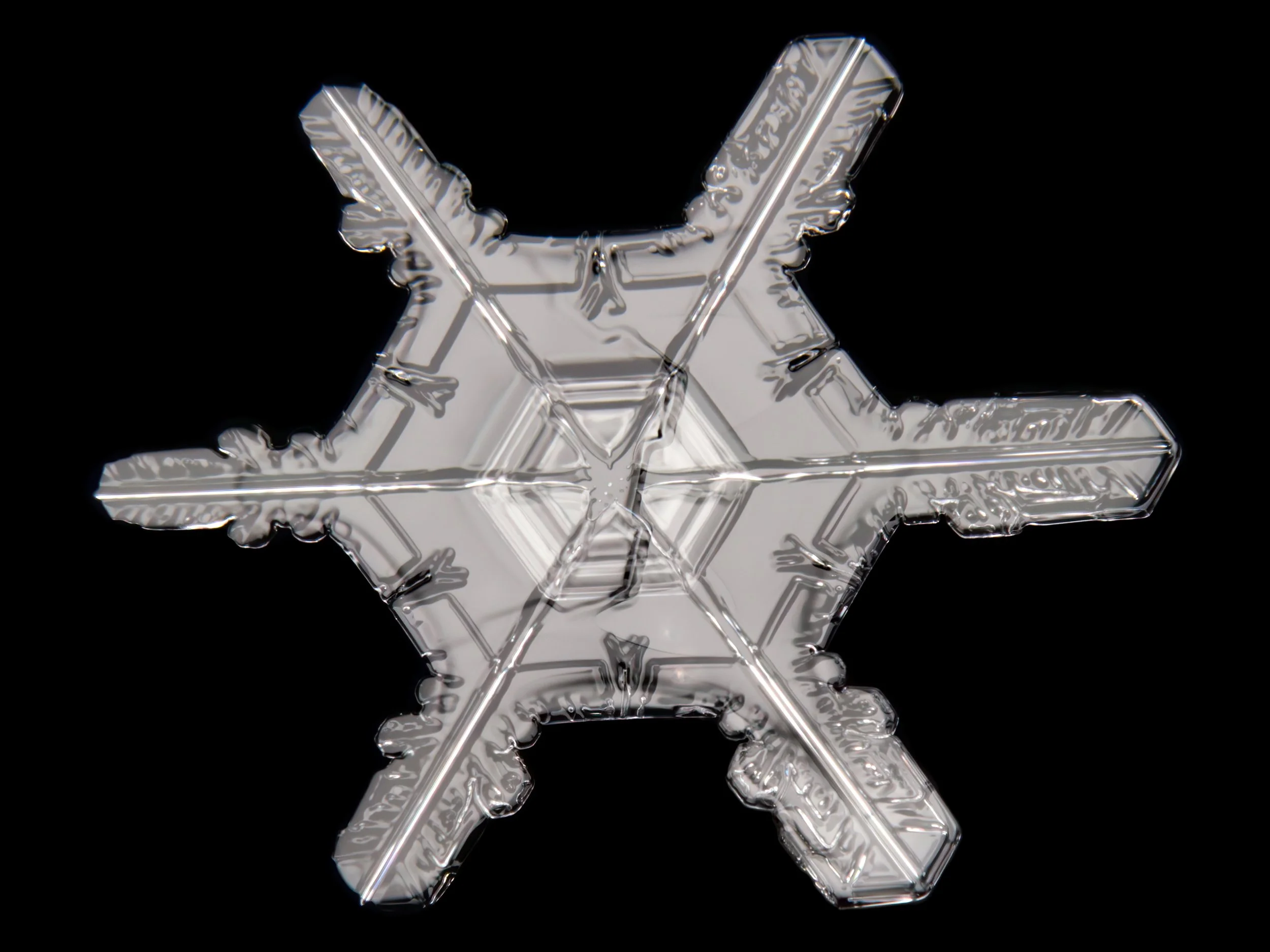 Macro photograph of a stellar dendrite snowflake with a large center part.