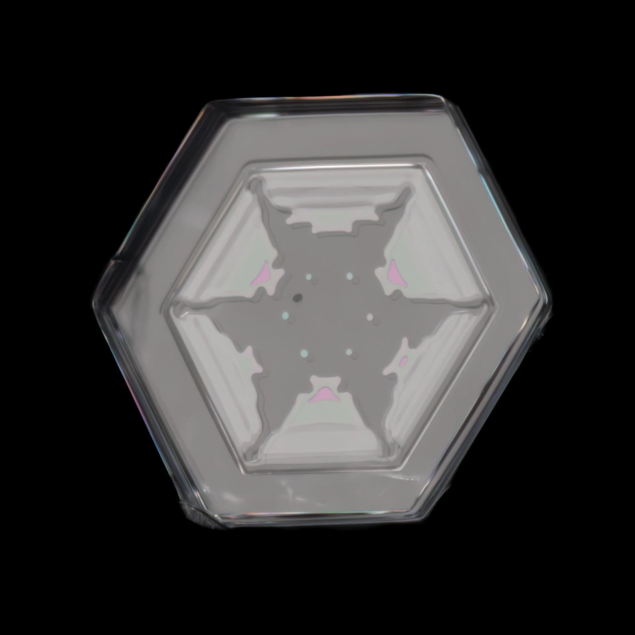 Macro photograph of a clear simple plate snowflake with a prismatic color refraction.