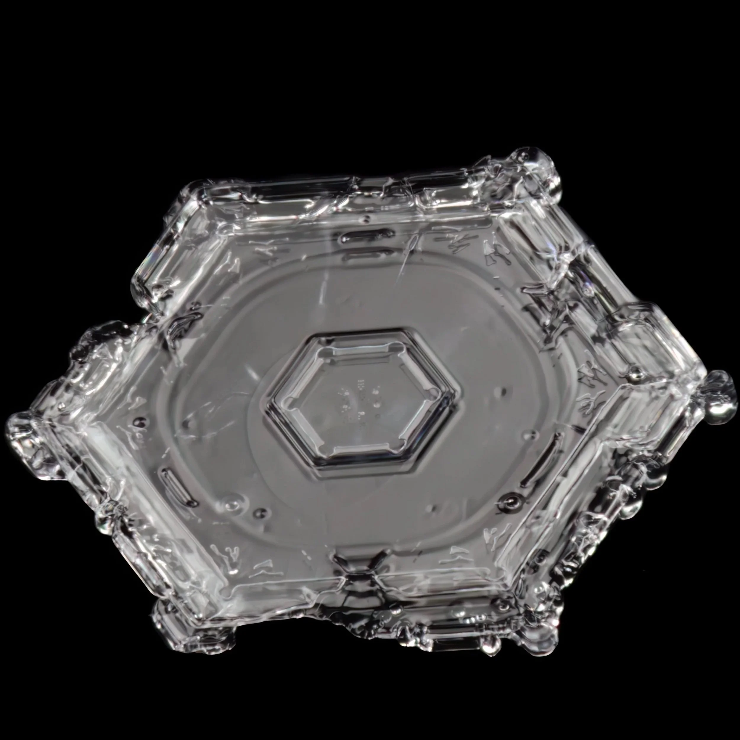 Macro photograph of a hexagonal-shaped plate snow crystal with beveled edges.