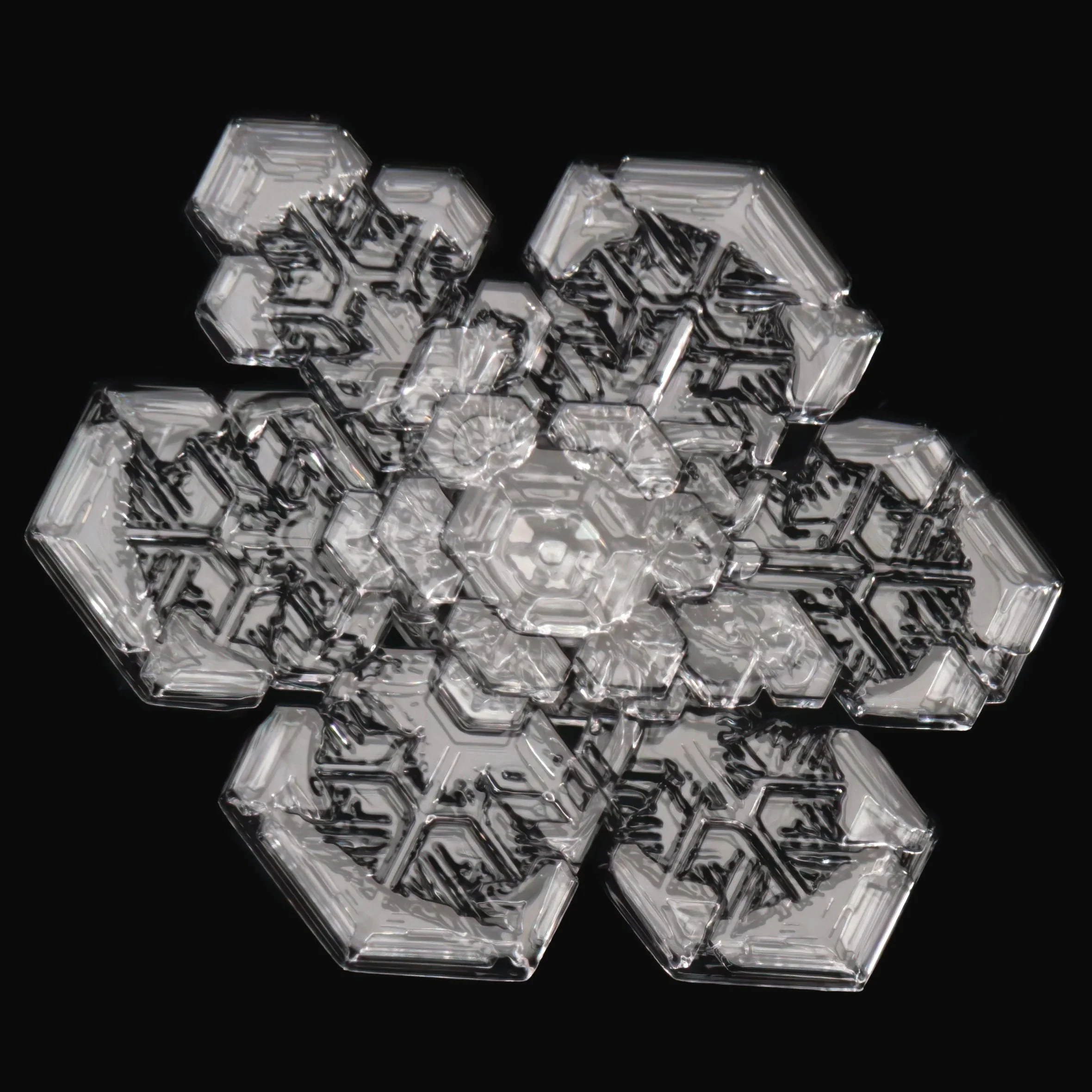 Macro photograph of a decorative snowflake made of transparent hexagonal and flower-shaped textures.