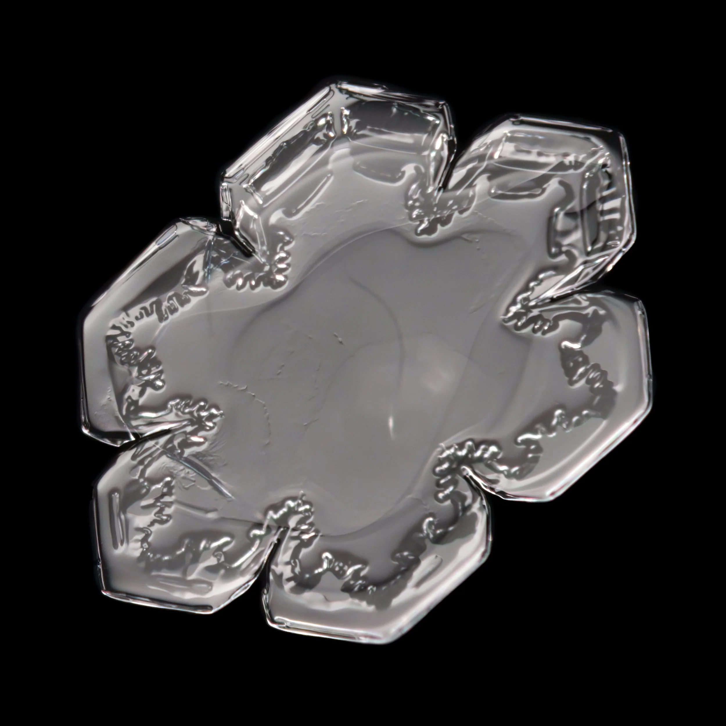 Macro photograph of a sectored plate snowflake with simple hexagonal structure.