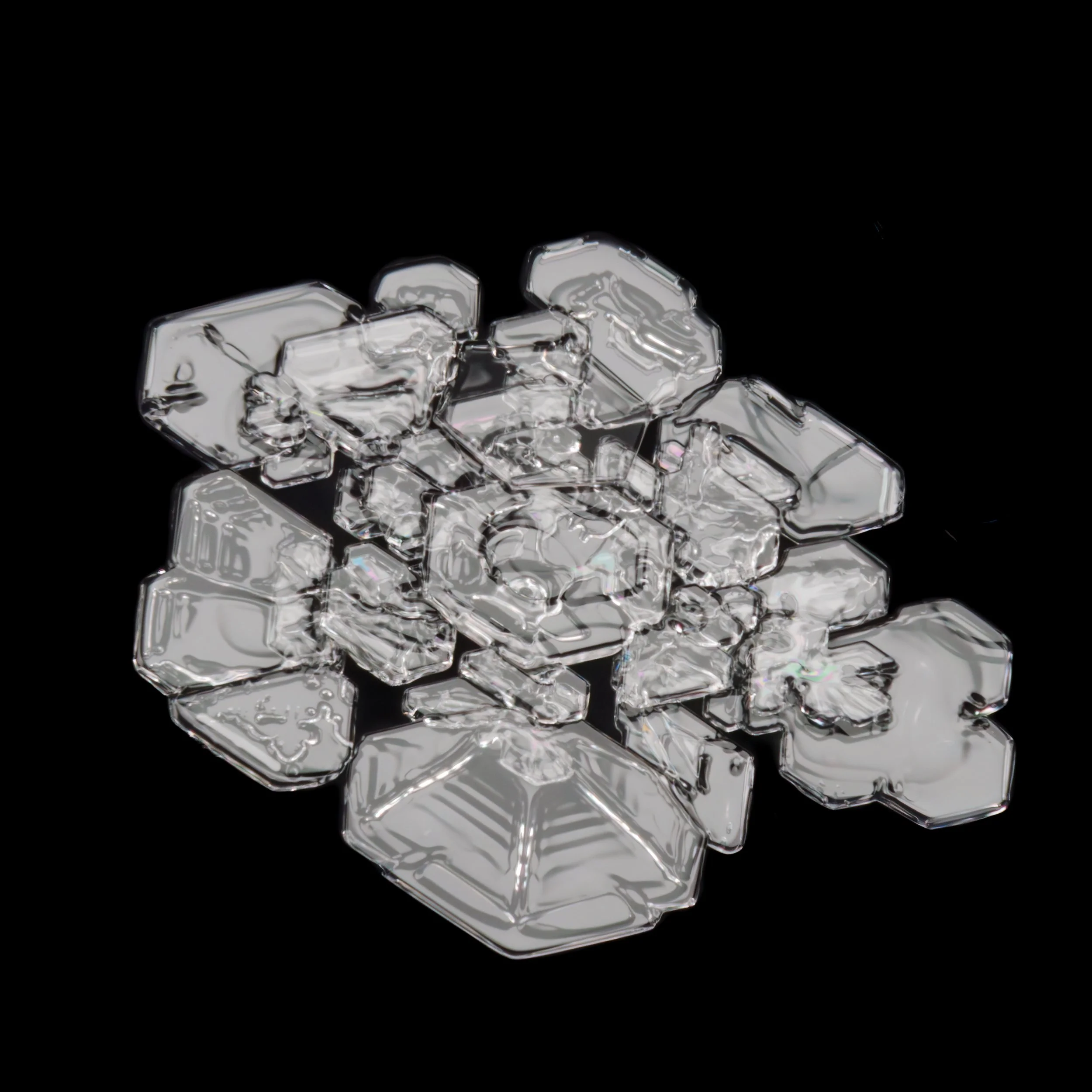 Macro photograph of a clear irregular shaped snowflake with variable sized branches.