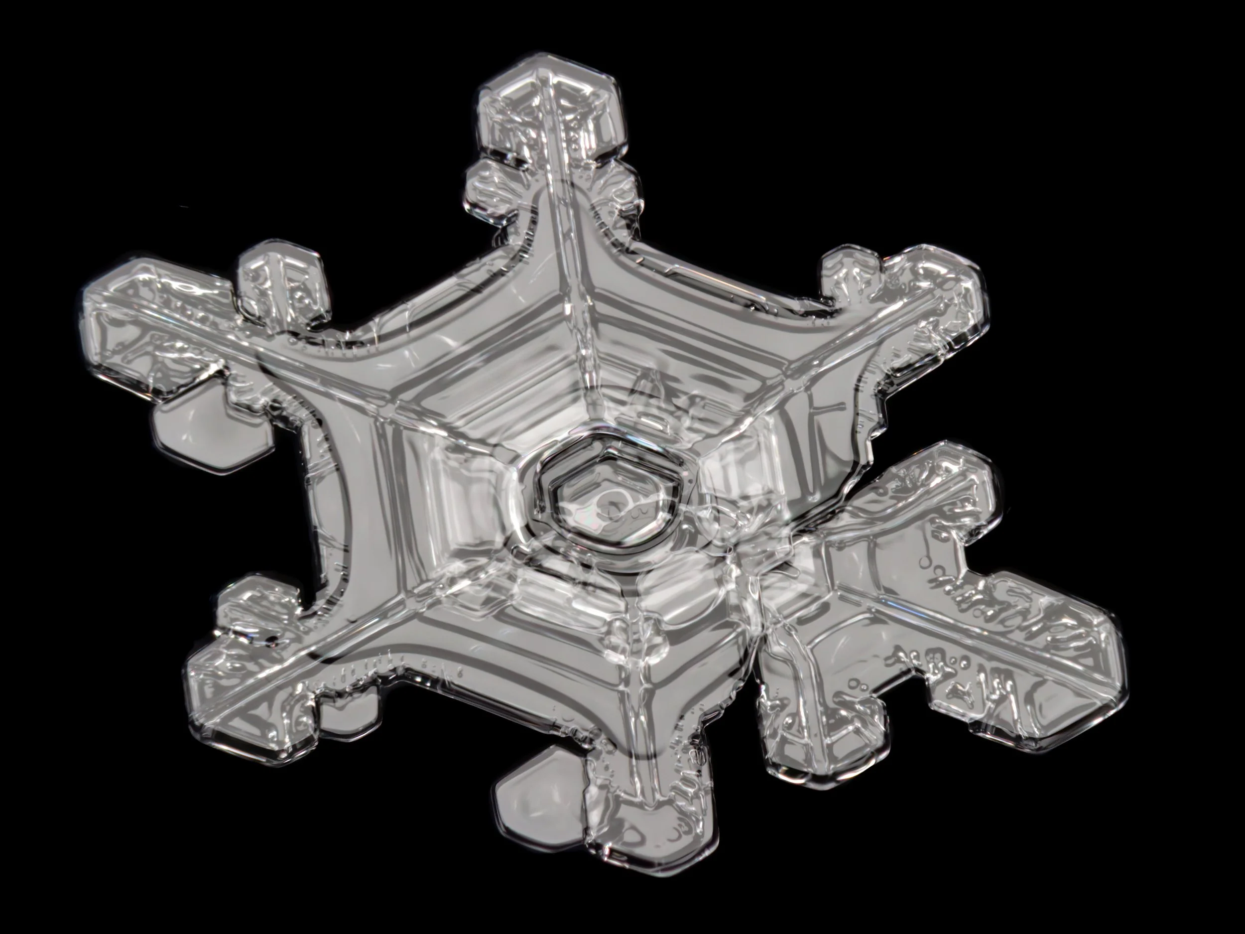 Macro photograph of a large sectored plate snow crystal with a distinctive center structure.