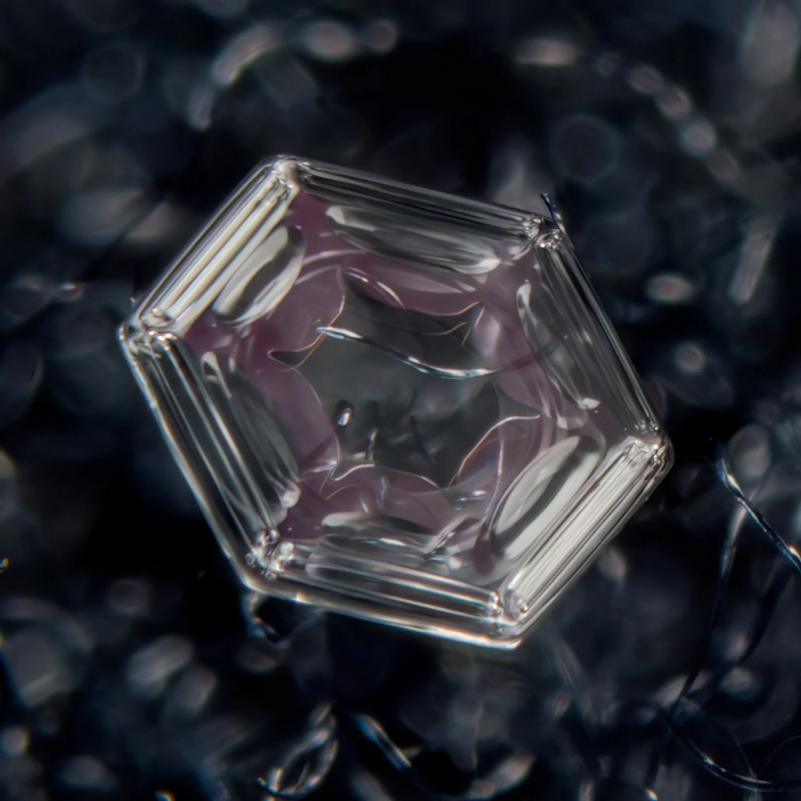 Macro photograph of a single translucent snow crystal.