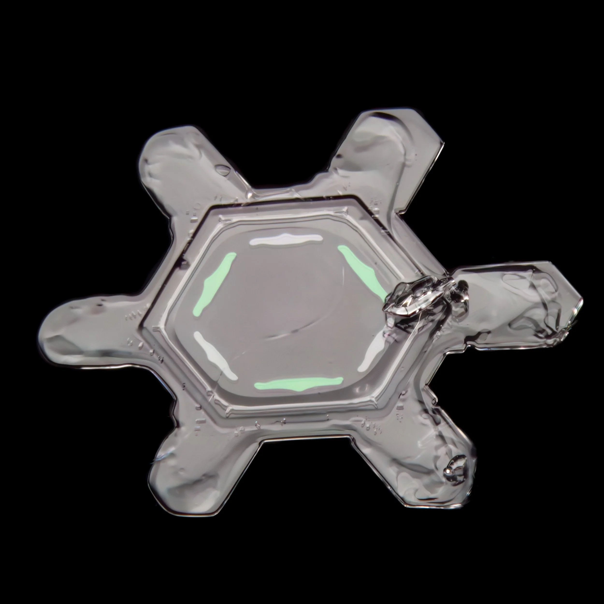 Macro photograph of a sectored plate snow crystal with colourful patterns in the center part.