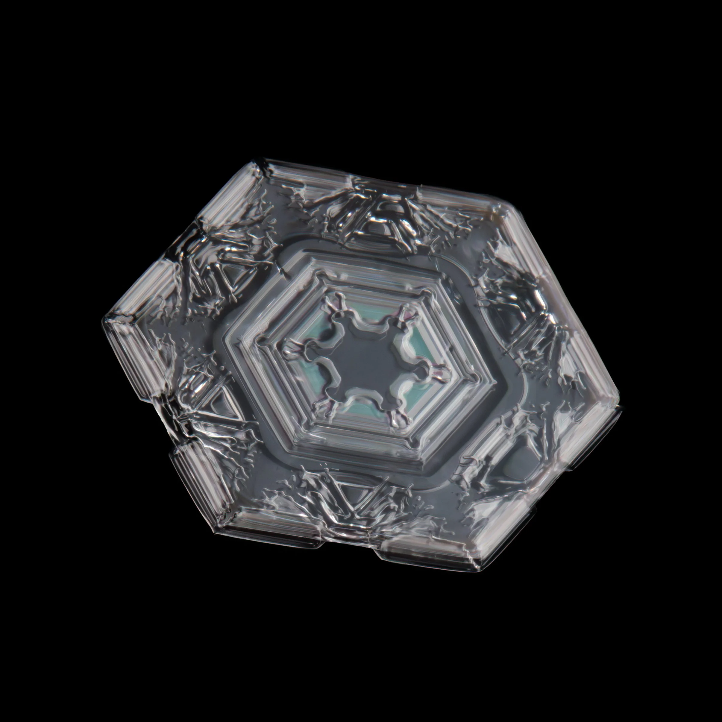 Macro photograph of a single plate shaped snowflake with intricate hexagonal and star-shaped patterns.
