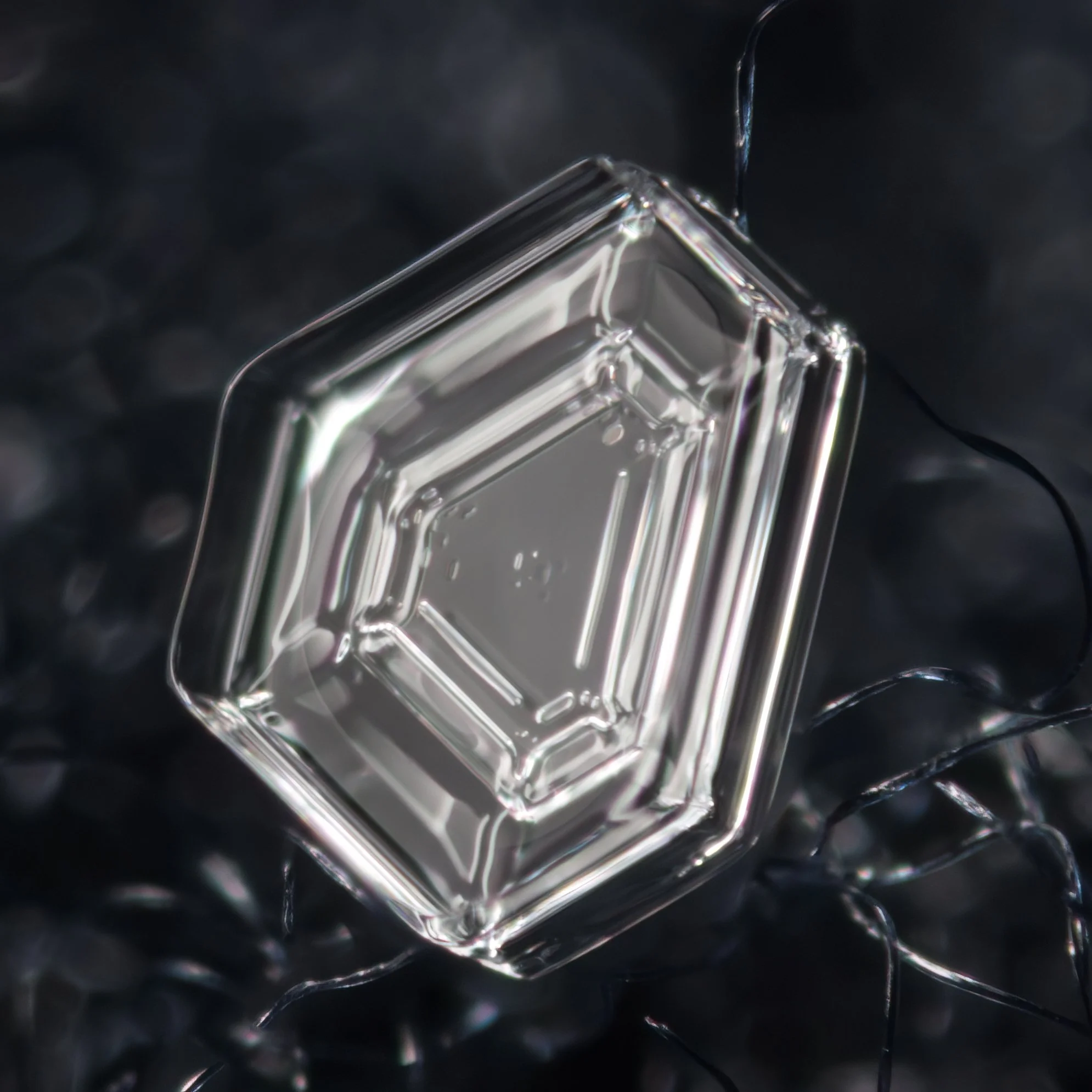 Macro photograph of a hollow hexagonal plate snow crystal.