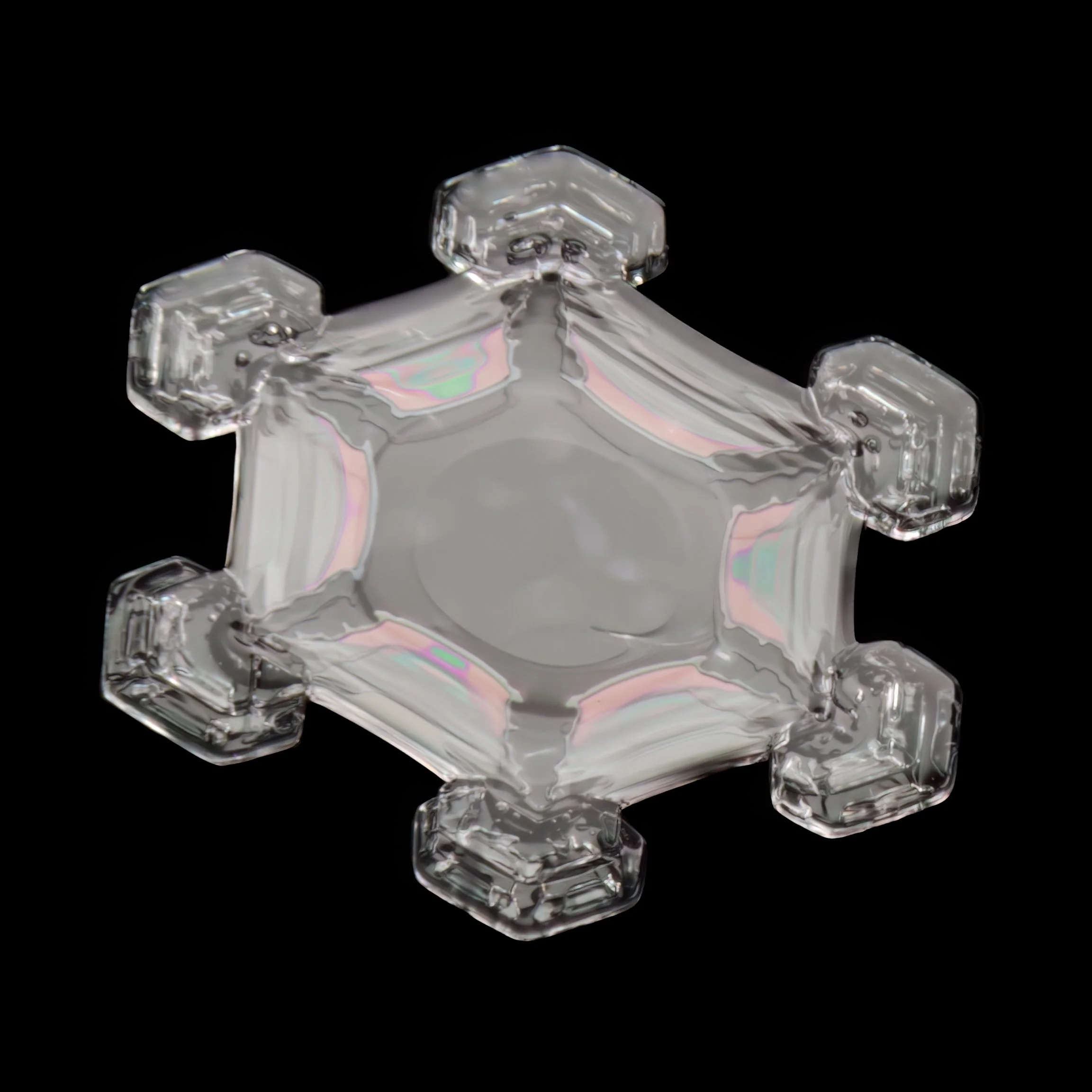 Macro photograph of a clear glassy snow crystal with a hexagonal shape and colours from thin film interference.