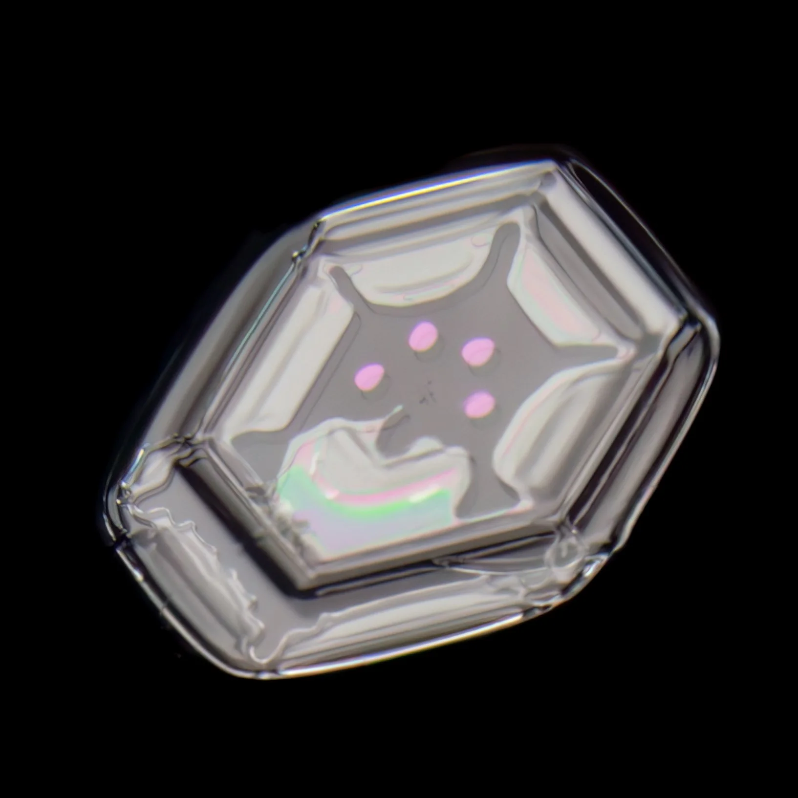 Macro photograph of a small plate snowflake with colorful patterns in the center part.