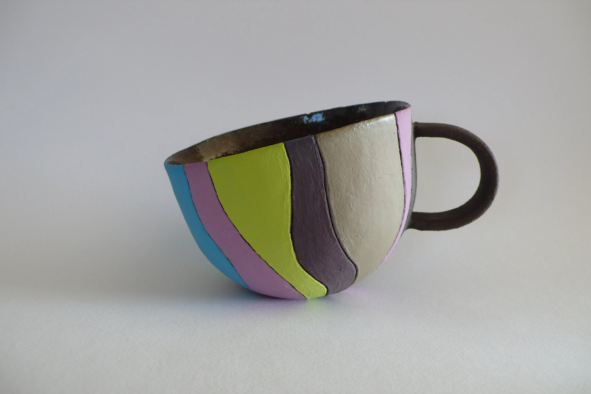 Hand-built black stoneware cup with multi-colored rhythmic inlaid slips by Marisa Iona.