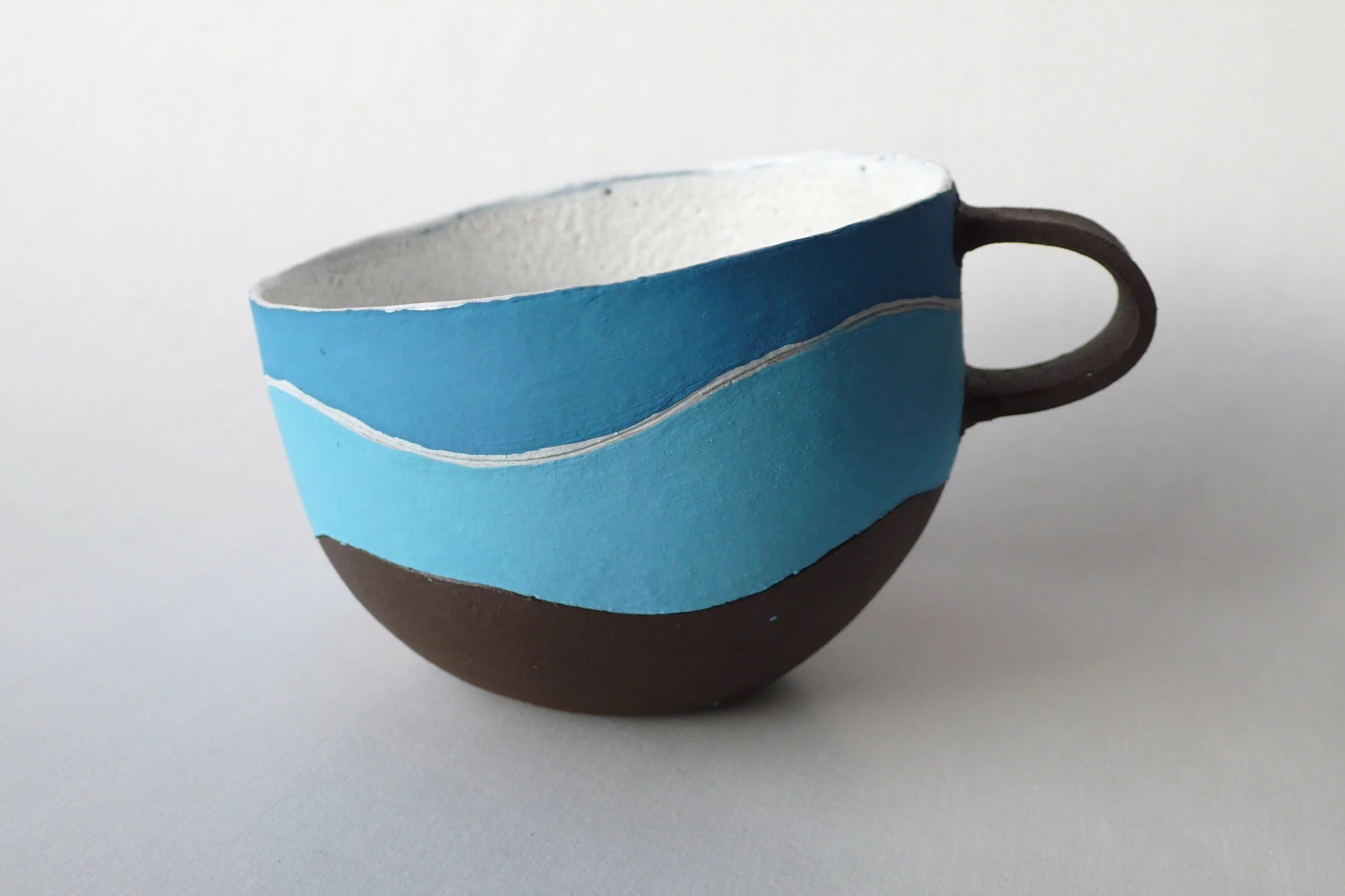 Contemporary hand-built black stoneware cup with blue rhythmic inlaid slips from the Celestial Rhythm series by Marisa Iona.