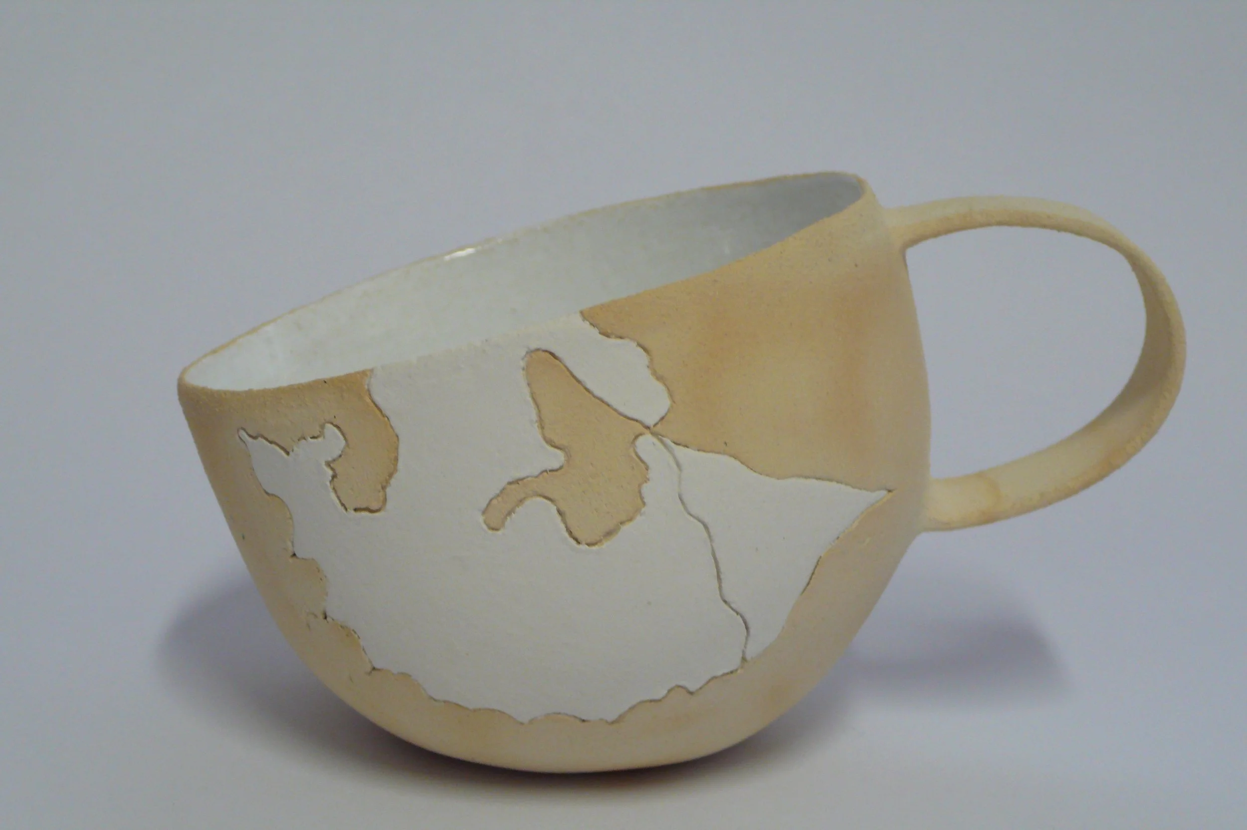 Minimalist hand-built ceramic cup with hand-carved white geometric inlay on raw stoneware by Marisa Iona.