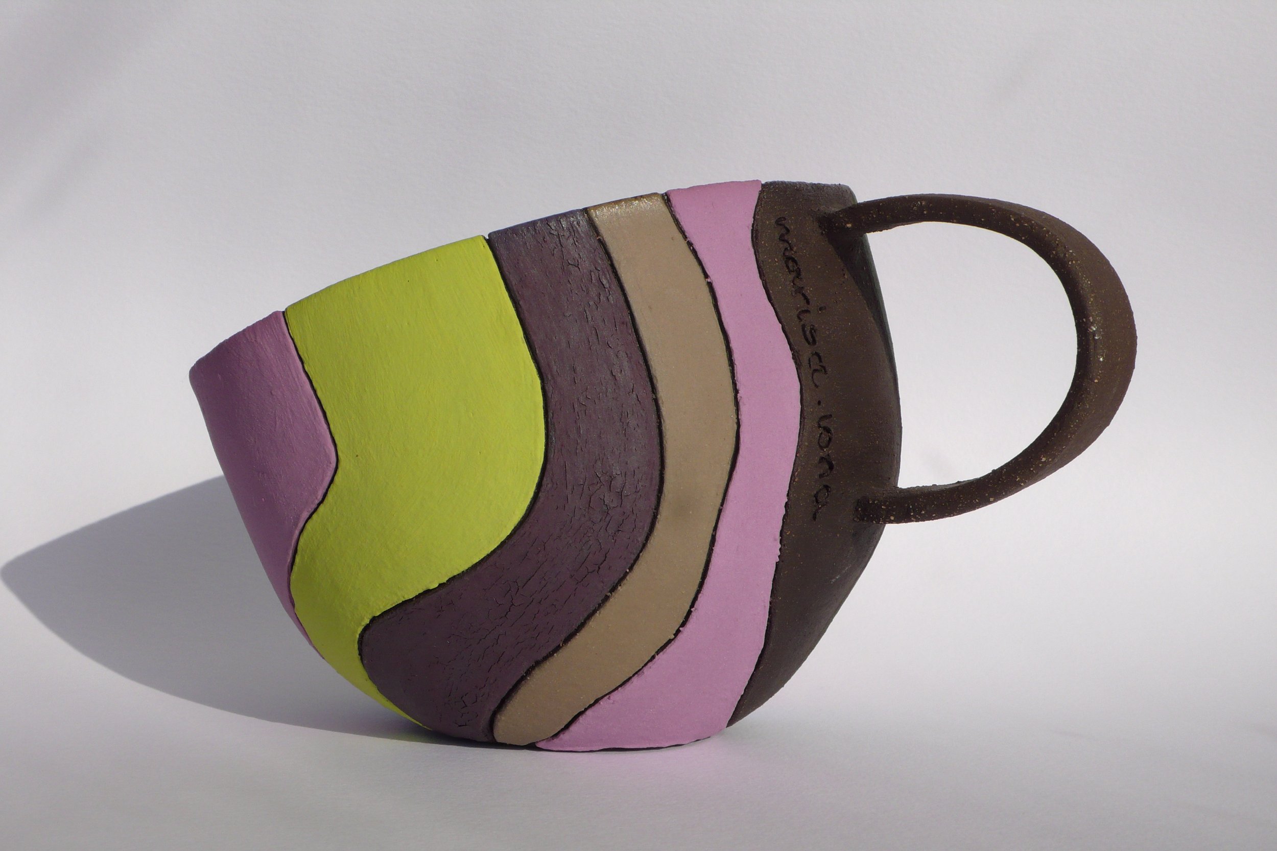 Hand-built black stoneware cup with multi-colored rhythmic inlaid slips by Marisa Iona.