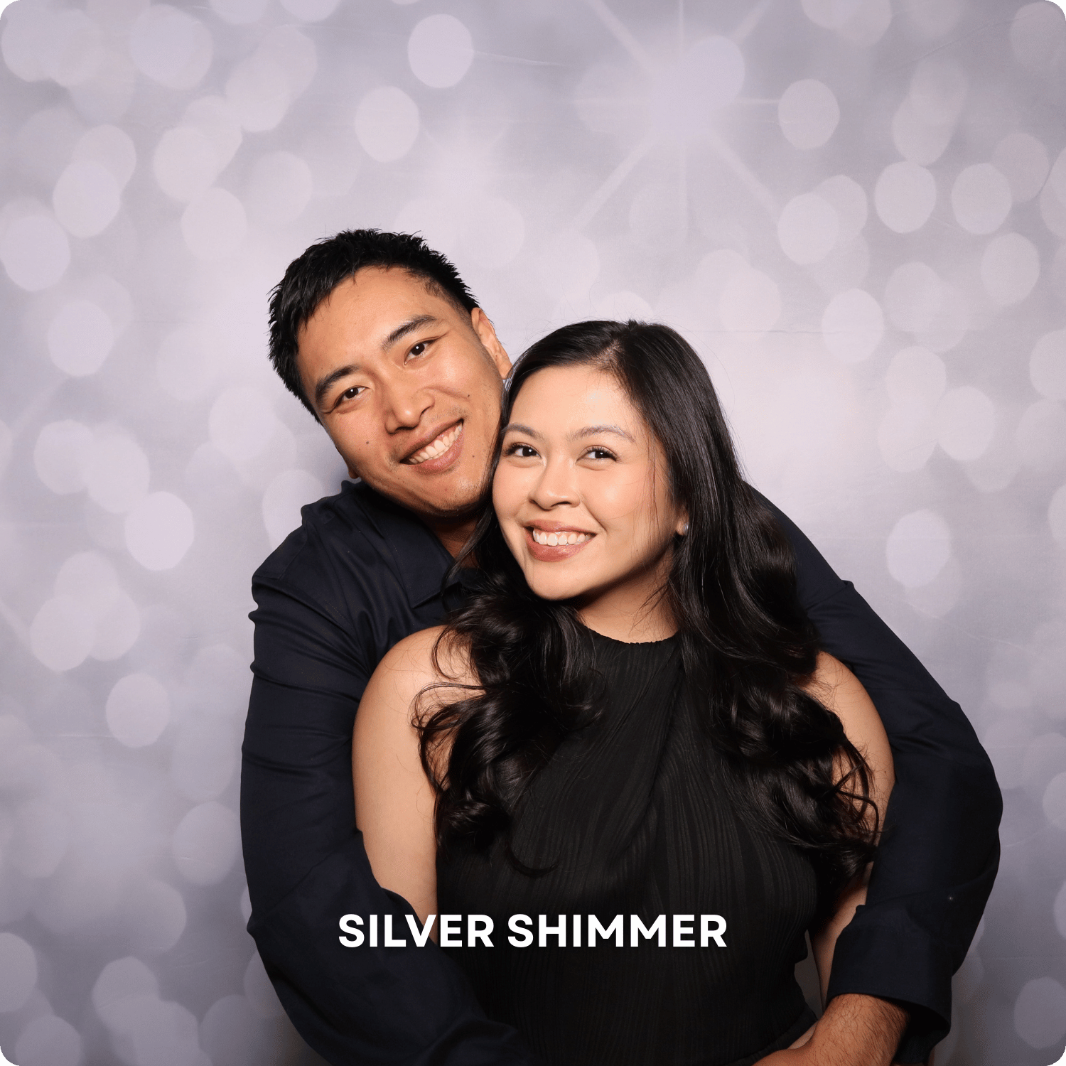 A smiling Asian couple embracing in front of a gray bokeh background, with the caption 'SILVER SHIMMER' at the bottom.