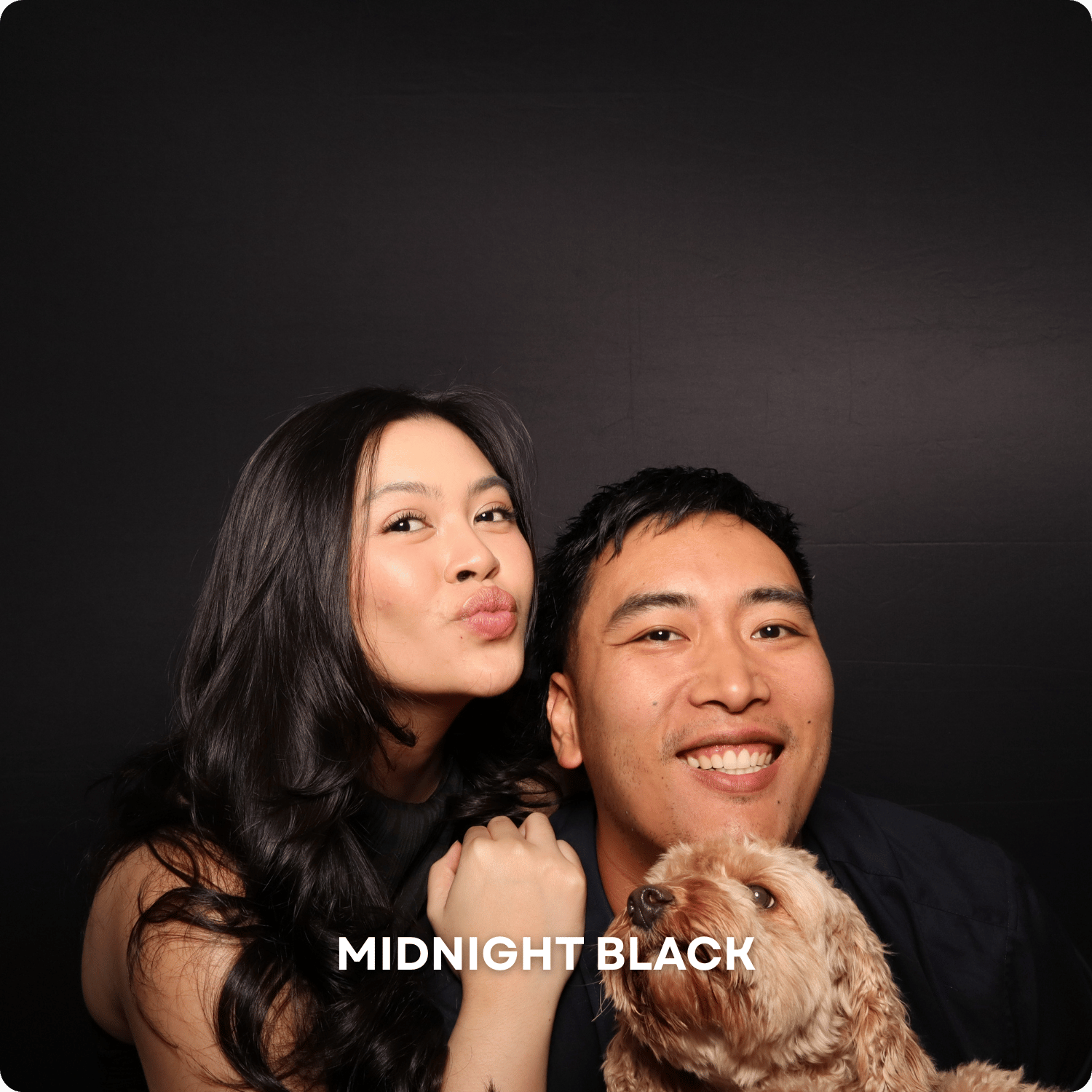 A woman and a man smiling, with a small dog in front of them, against a black background, with the text 'MIDNIGHT BLACK' at the bottom.