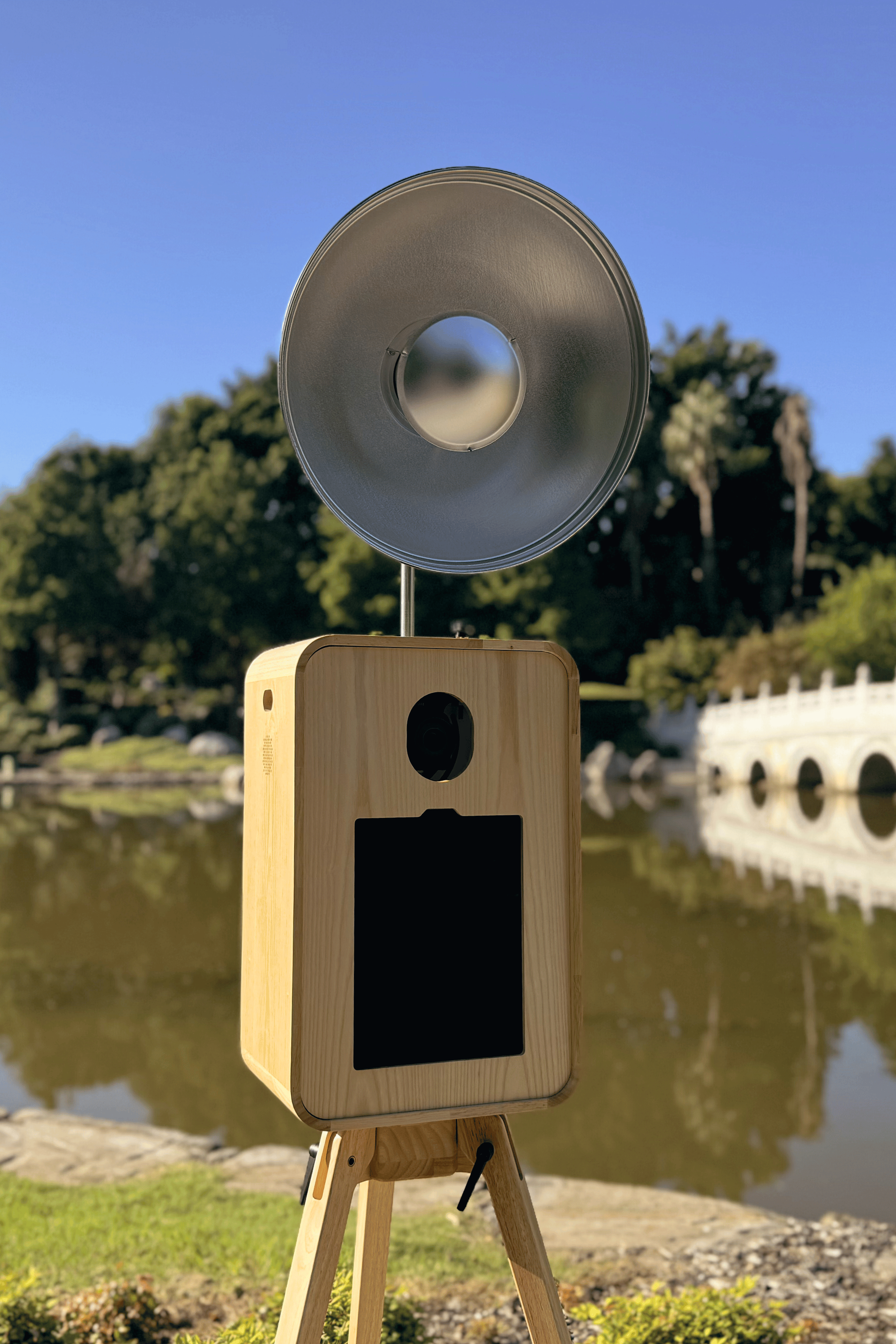A wooden oak wood photobooth case with a beauty dish mounted on top, perfect for indoor and outdoor events.