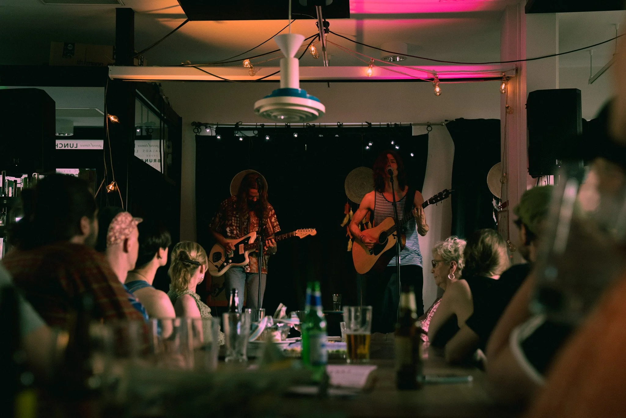 Musiikki esiintymässä pienellä Loungessa, jossa on kaksi naisartisti ja yleisö istuu pöydissä.