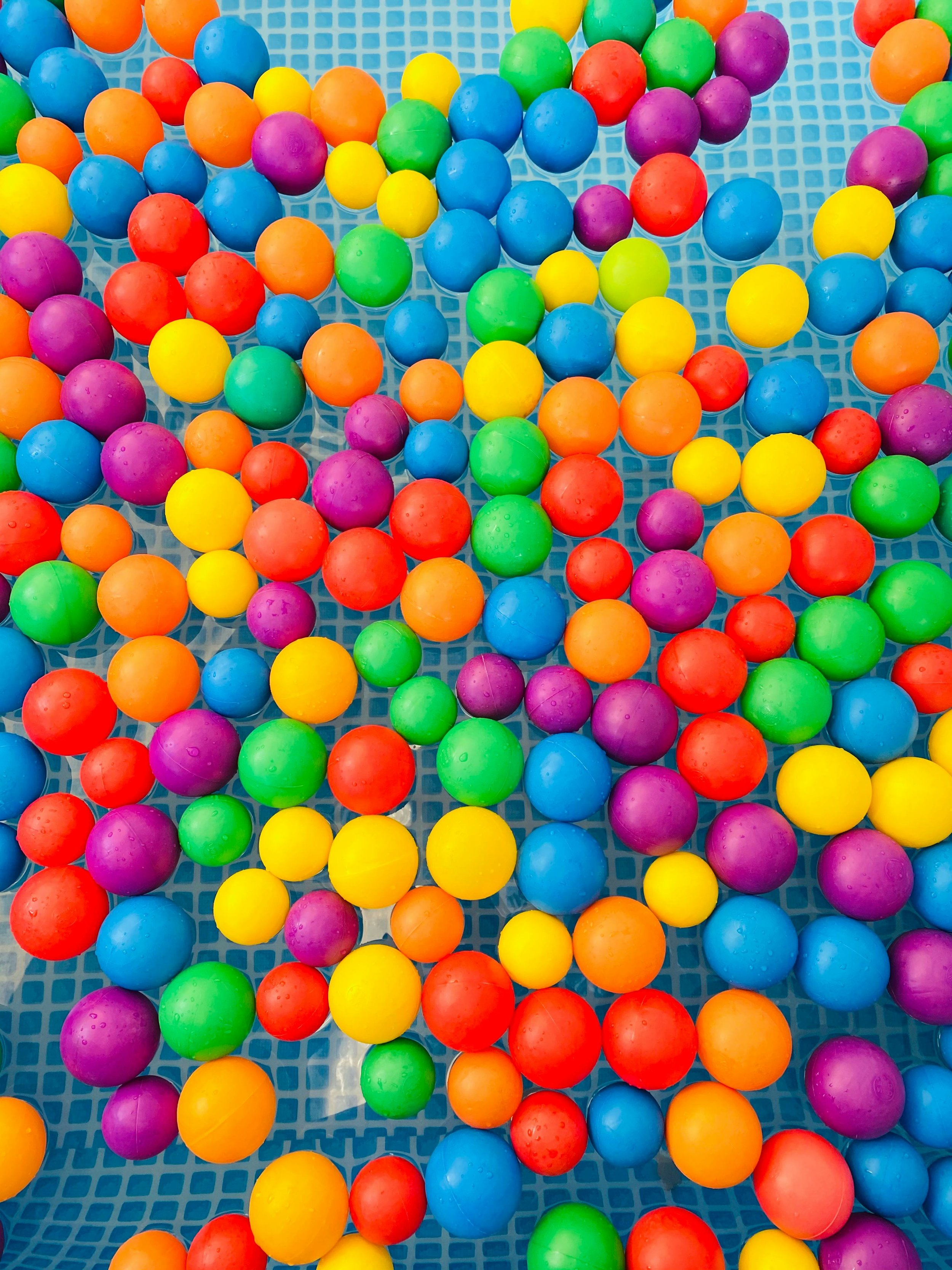 Colorful plastic balls scattered in a blue mesh container.