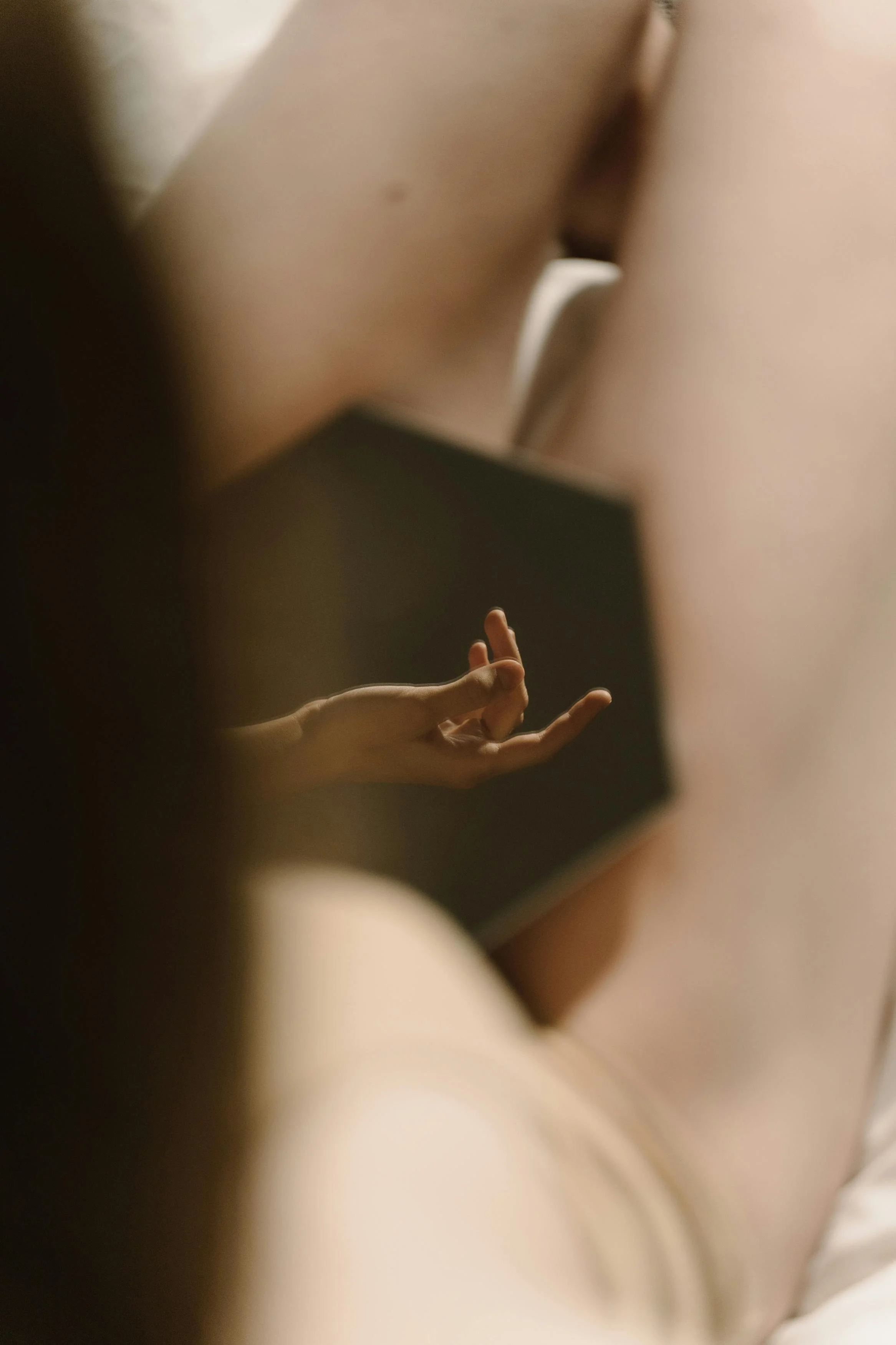A person using a tablet, with their hand in a mudra position, viewed from a low angle.