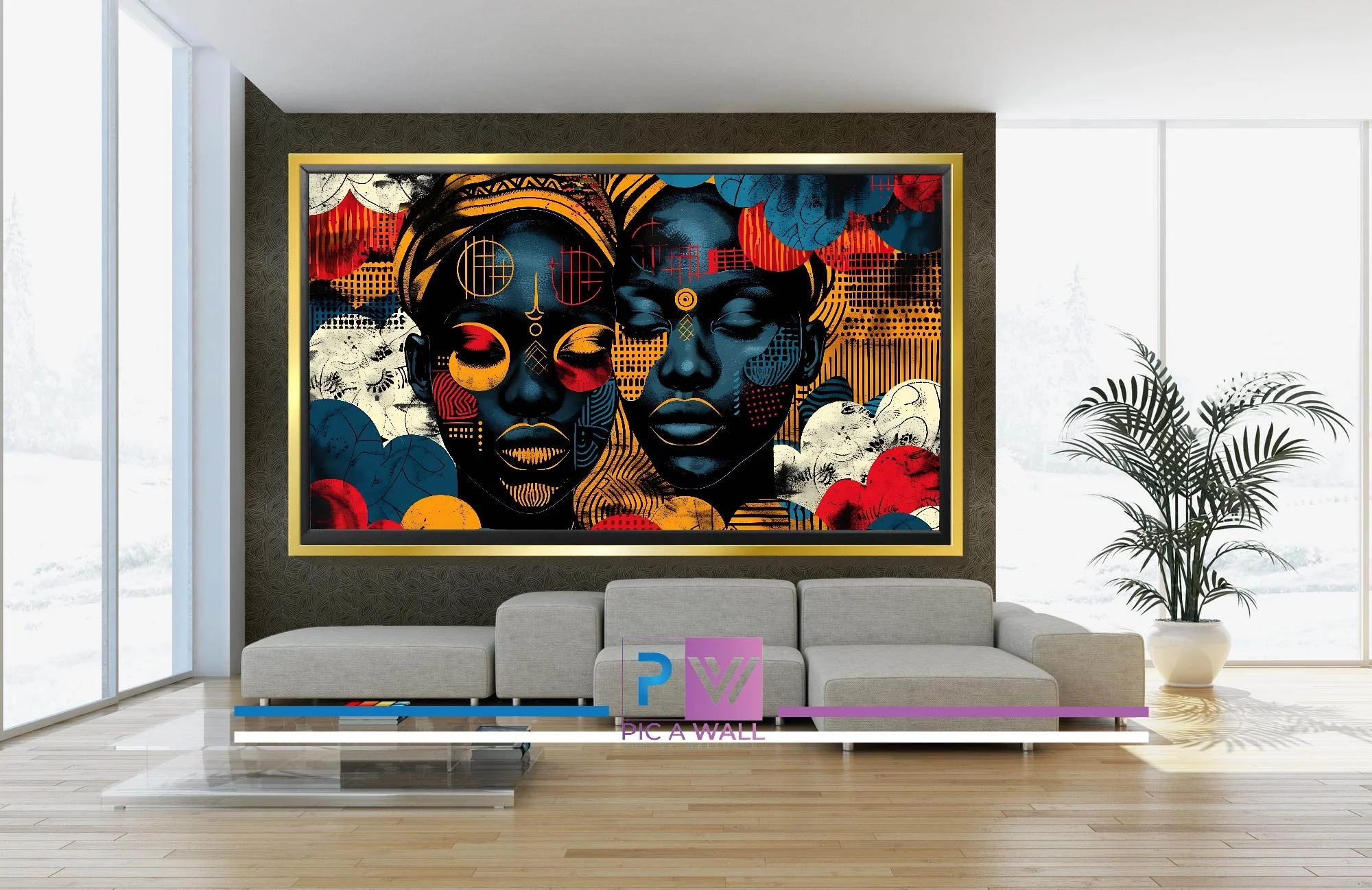 Modern living room with large colorful artwork of two African women on the wall, a gray sectional sofa, a glass coffee table, a potted plant, large windows, and a logo with the text 'Pic a Wall'.
