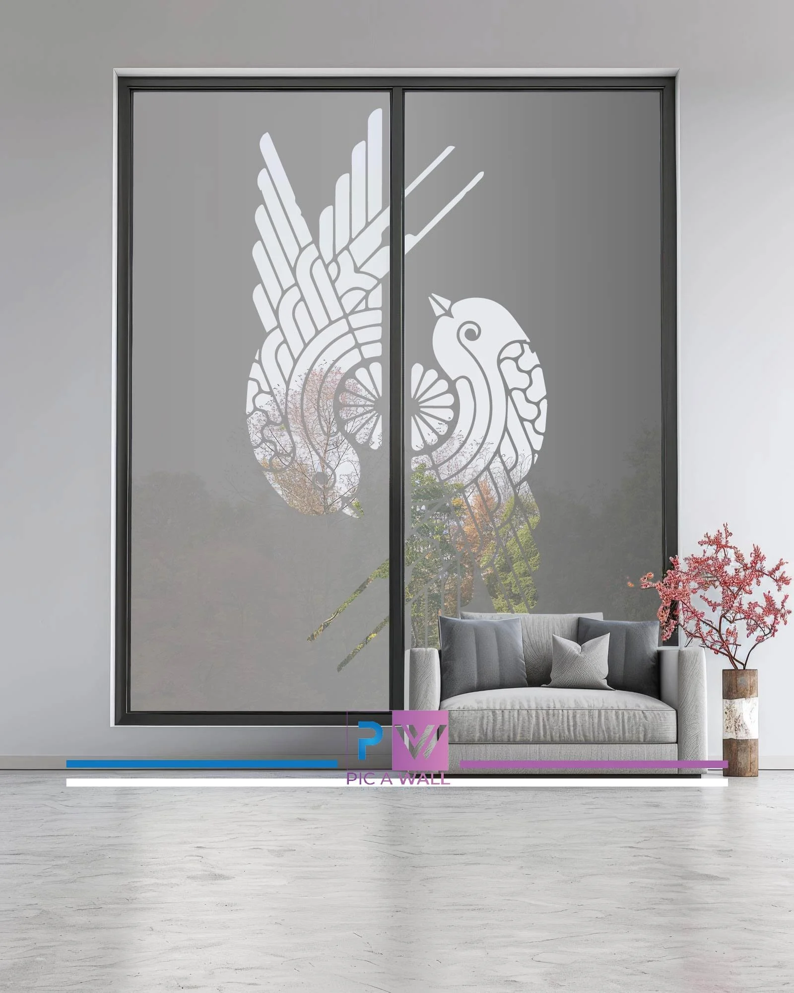 Decorative window with a bird design, situated above a gray couch with pillows, near a potted plant with pink flowers in a modern living room.
