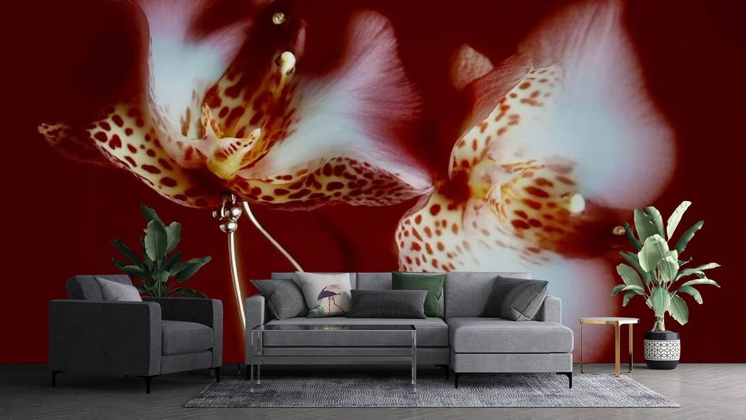 A living room with a large wall mural featuring close-up white and orange orchids with spotted patterns.