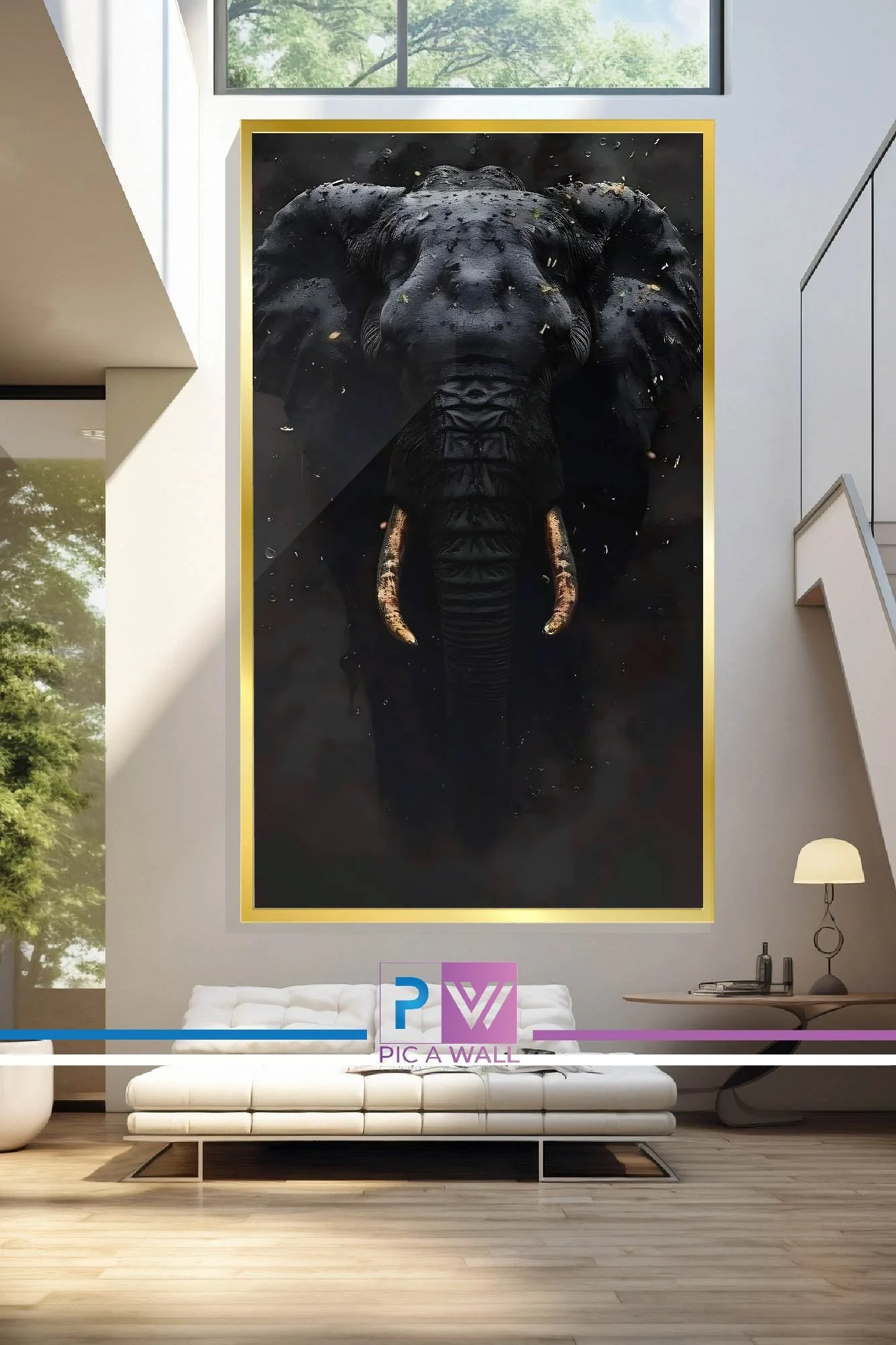 Large framed photograph of a black elephant with its trunk pointing downward, hanging on a modern interior wall above a white sofa.