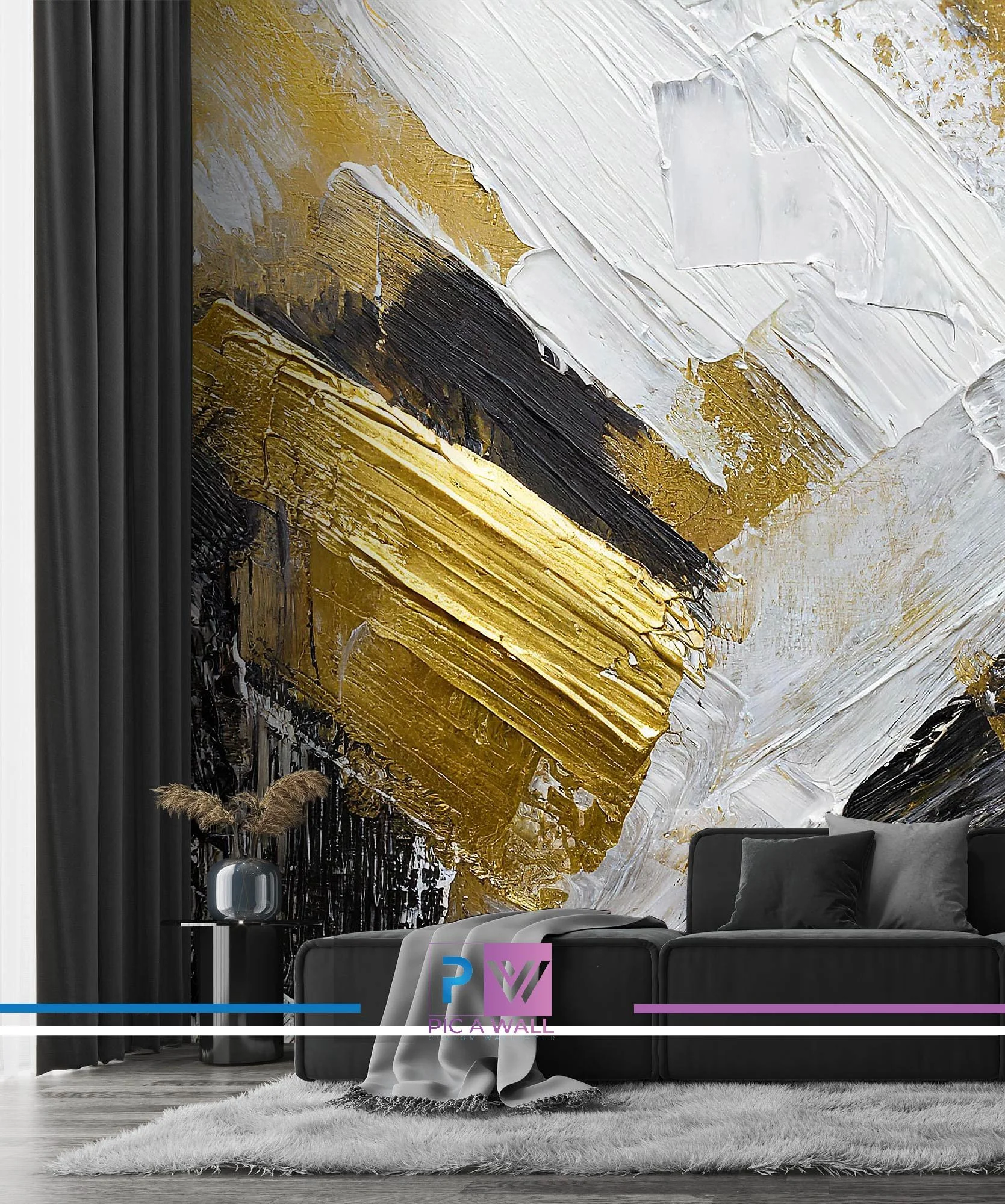 Modern living room with a large abstract wall mural featuring bold strokes of gold, black, and white paint. There is a dark gray sofa with black and gray pillows, a white furry rug, and a small round side table with a vase holding dried pampas grass. Black curtains are visible on the left side.