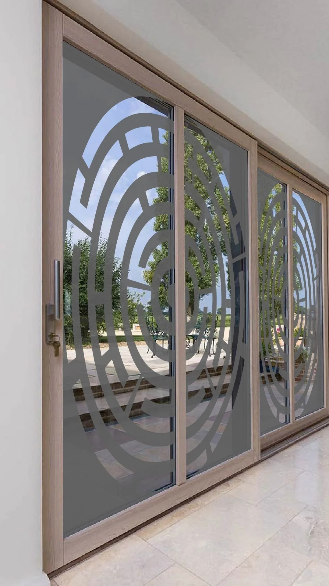 Sliding glass door with a wooden frame and decorative maze-like pattern, through which trees and a blue sky are visible outside.