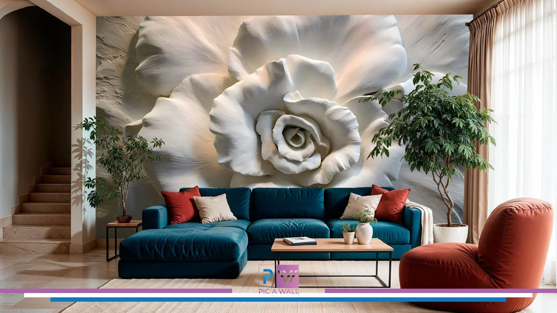 Living room decorated with a large white floral mural on the wall, a dark teal sectional sofa with beige and red pillows, a round rust-colored lounge chair, potted plants, a wooden coffee table, and sheer curtains on the right.