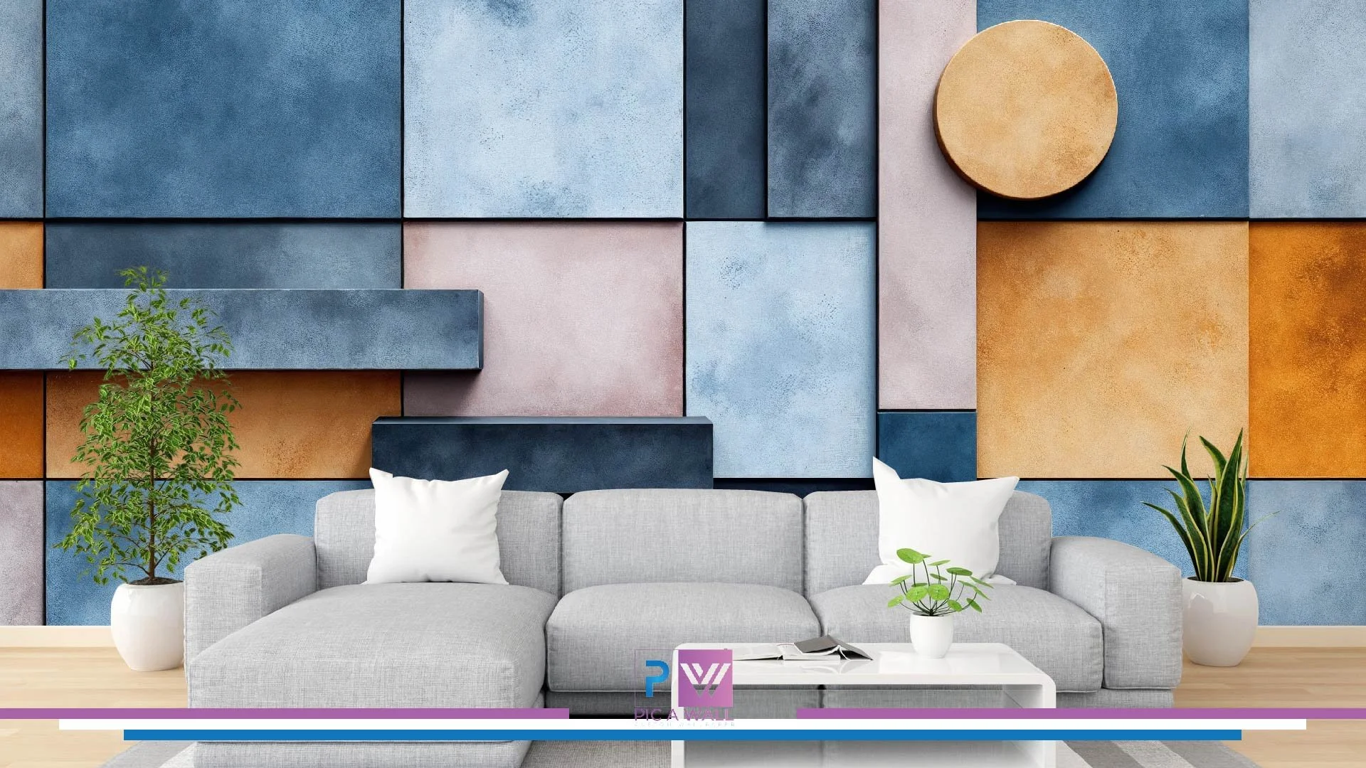 Modern living room with a light gray sofa, two white pillows, and potted green plants on a white coffee table and on the floor. The wall has large, colorful geometric panels in shades of blue, dusty pink, and warm orange, with a round wooden art piece on the right side.