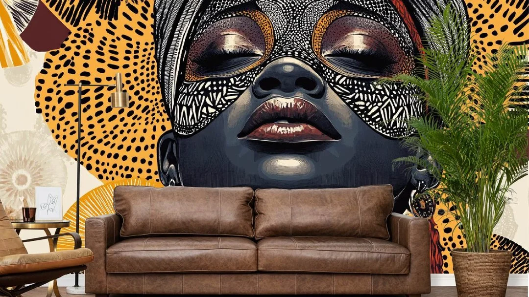 A large wall mural of an African woman with tribal face paint and adornments, positioned behind a brown leather sofa and near a potted plant in a cozy living room.