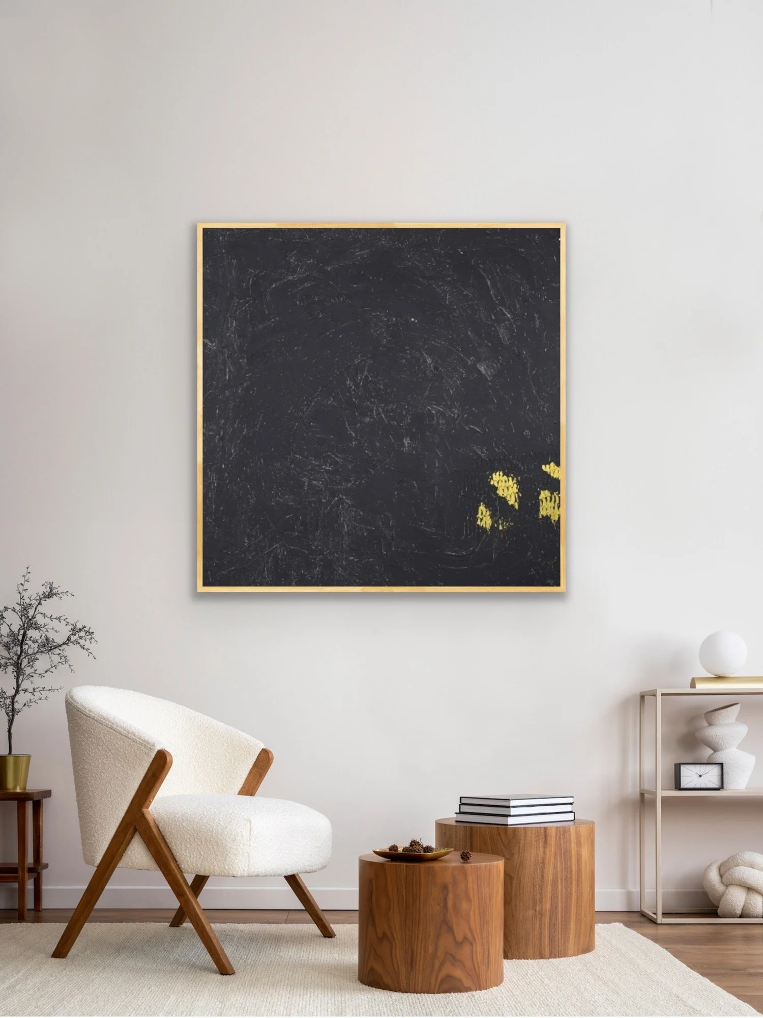 Moderner Wohnzimmerbereich mit einem weißen Sessel aus bunten Holzrahmen, einem kleinen Beistelltisch, einem Regal mit Dekorationsobjekten und einer großen schwarzen Tafel mit gelbem Rahmen an der Wand.