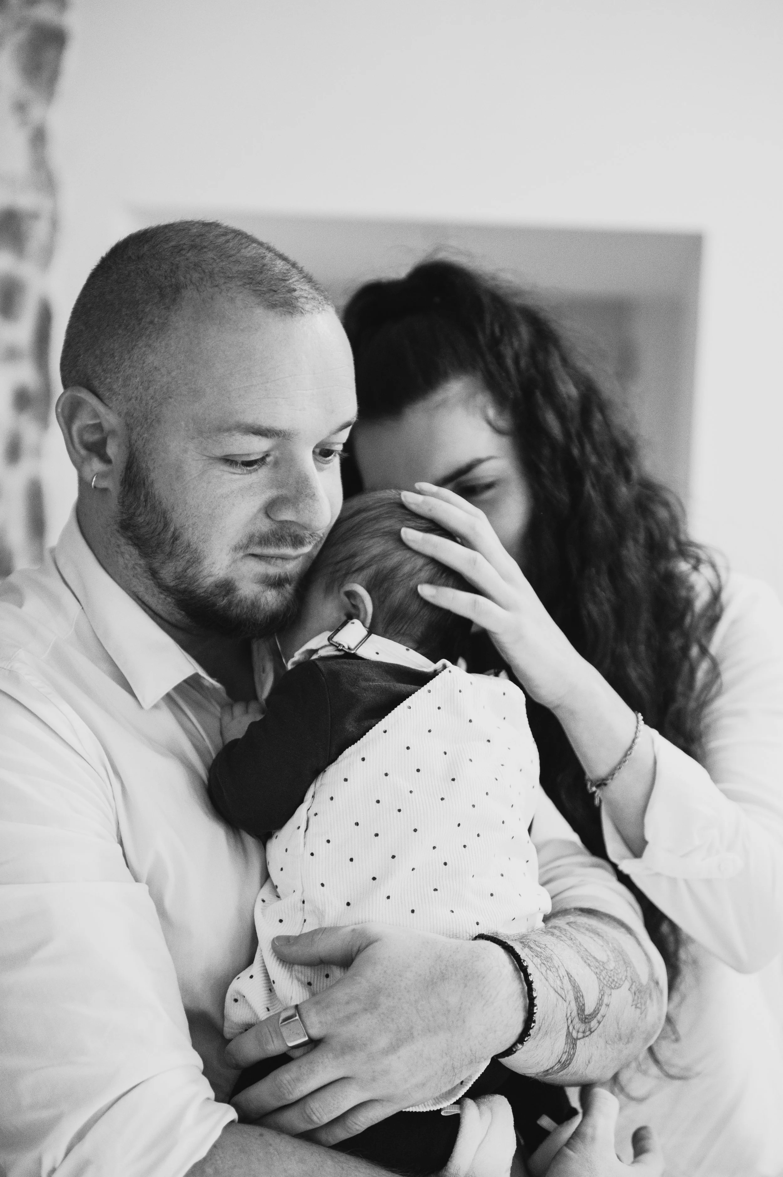bébé dans les bras de papa, caresse de maman