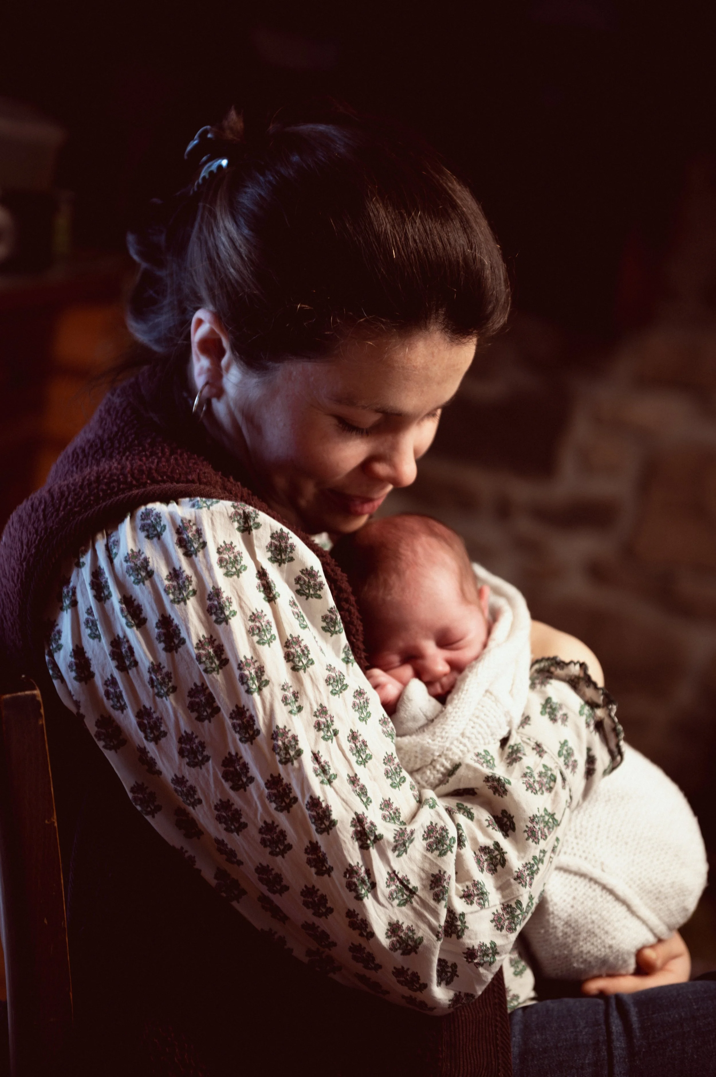 Bébé lové contre sa mère - clair-obscur
