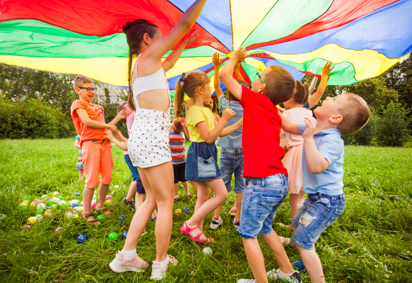 Kids playing together under a colorful parachute