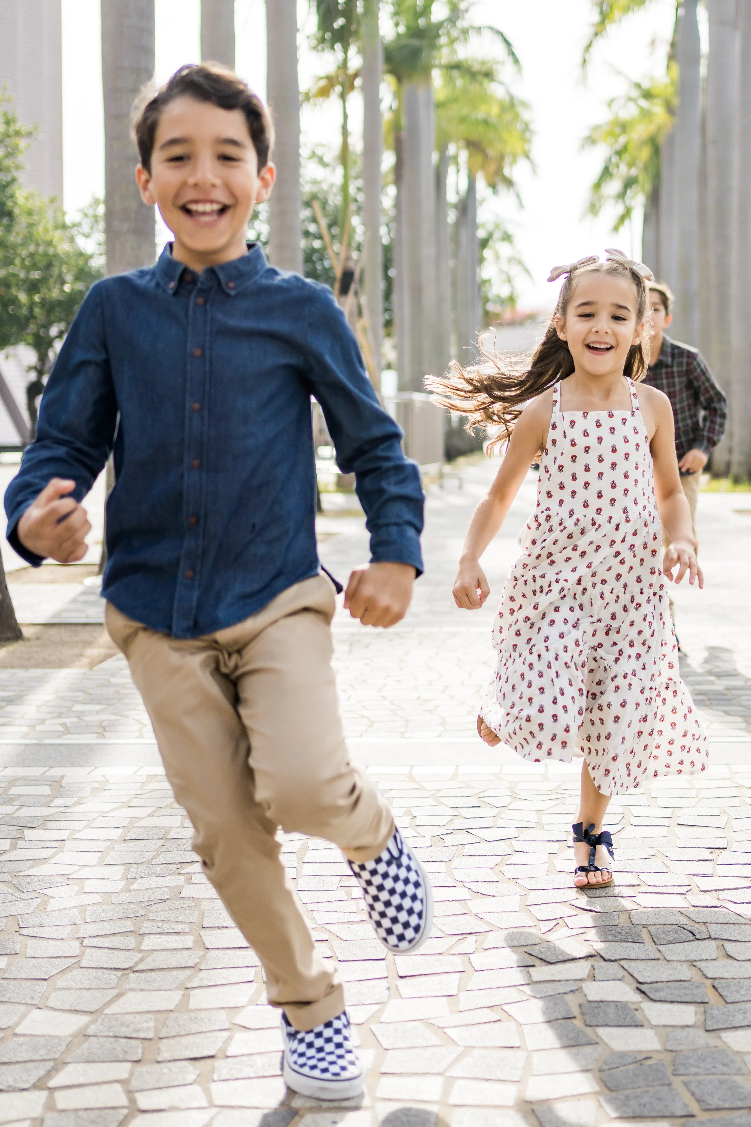 Two young children running towards the camera and smiling.
