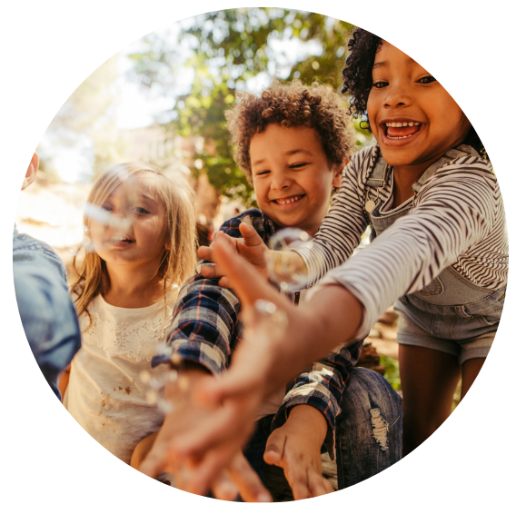 Kids chasing bubbles outside during the summer