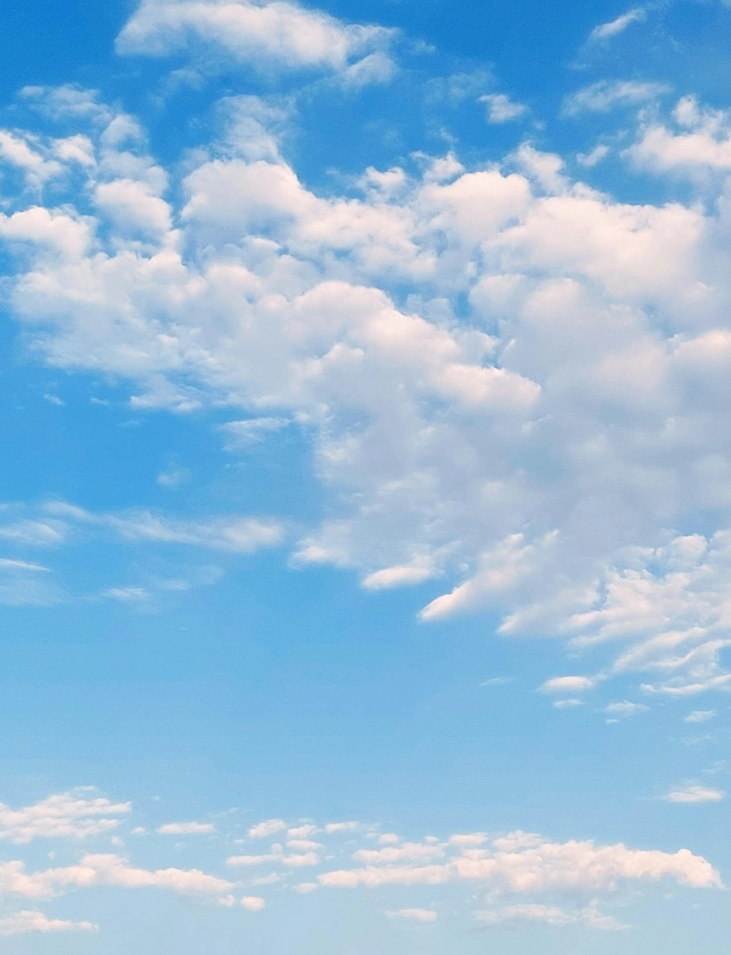 Blue sky with scattered white clouds.