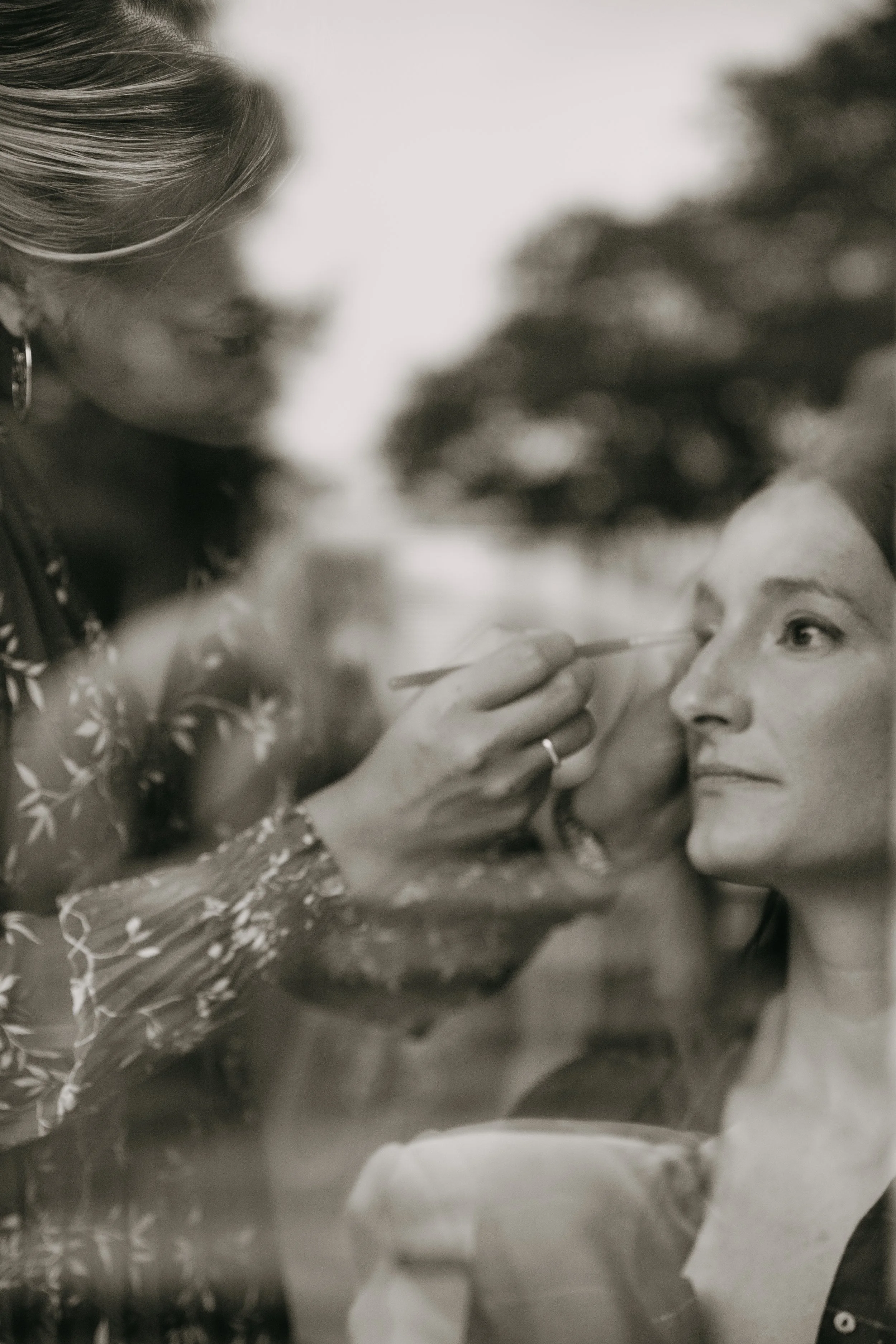 Une femme réalise un maquillage dans un miroir.