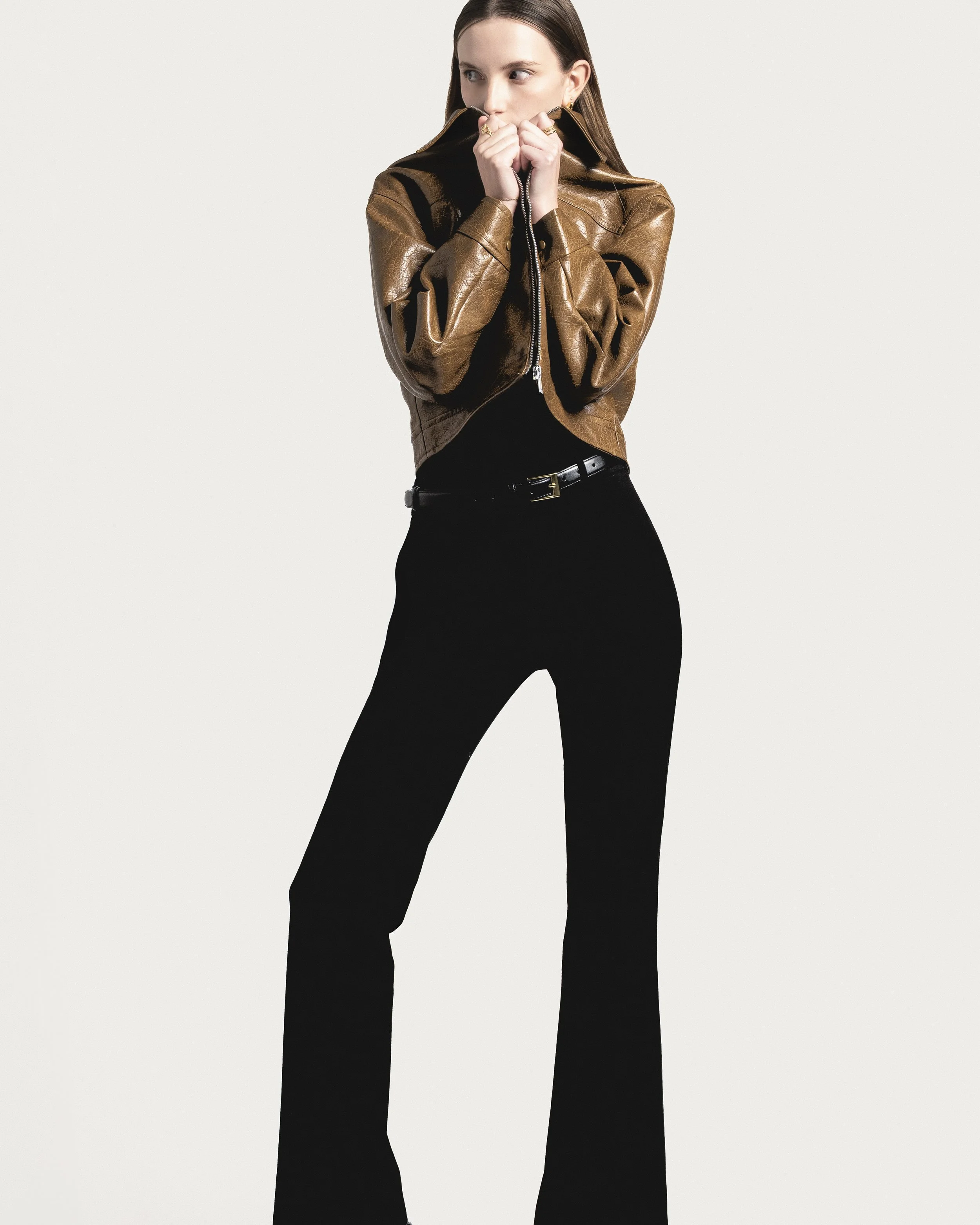 Femme portant une veste en cuir marron et un pantalon noir